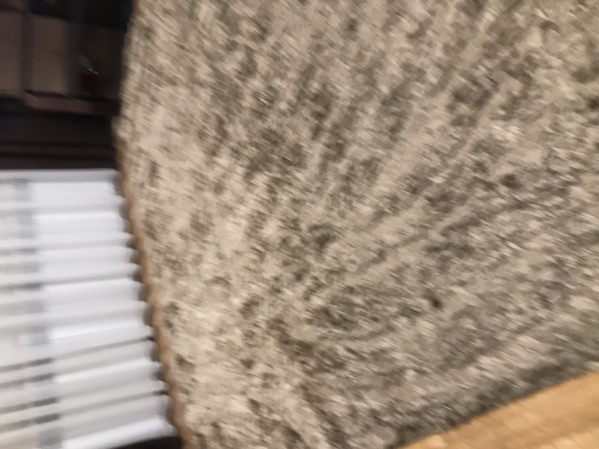 The image is blurred. It appears to show white venetian blinds next to a textured, possibly concrete, wall. The setting may be indoors. Yerevan, Armenia is not discernible from the image.