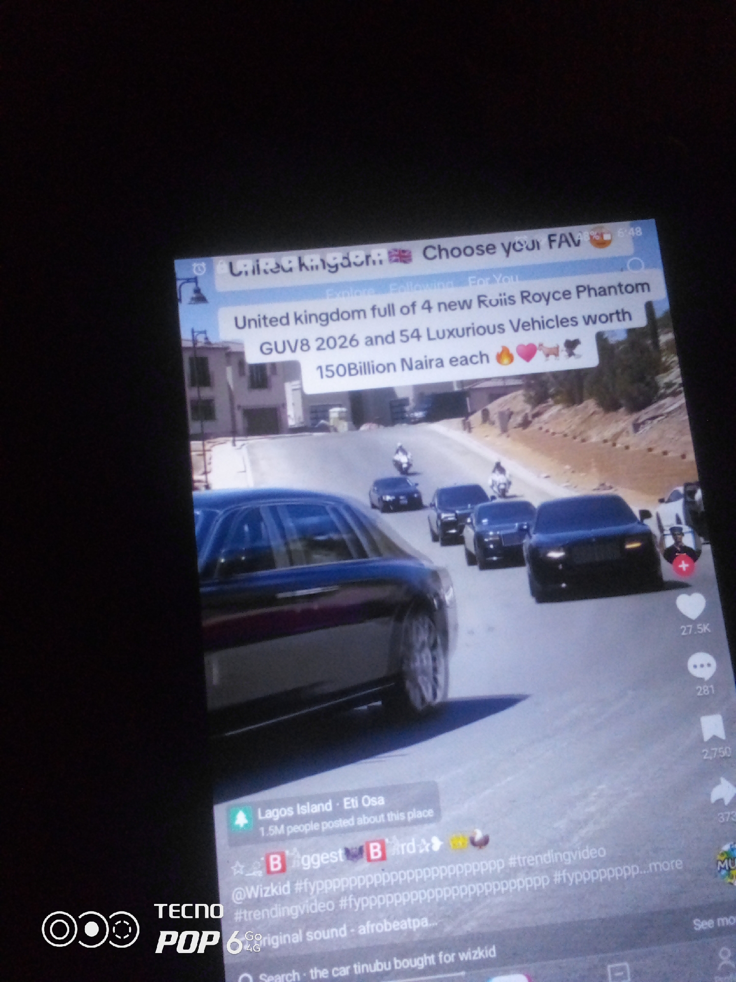 The image shows a smartphone screen displaying a social media video. The video appears to be a compilation of luxury cars, specifically Rolls-Royce Phantoms, in what seems to be a convoy. The text on the screen indicates "United kingdom" as the location and mentions "4 new Roliis Royce Phantom GUVS 2026 and 54 Luxurious Vehicles worth 150Billion Naira each". There are several black Rolls-Royce sedans and motorcycles visible in the video. Below the video, there are social media interaction icons like likes and comments. The user's Tecno Pop 6 4G phone is also visible. There is no indication of Howayi, Nigeria in the image.