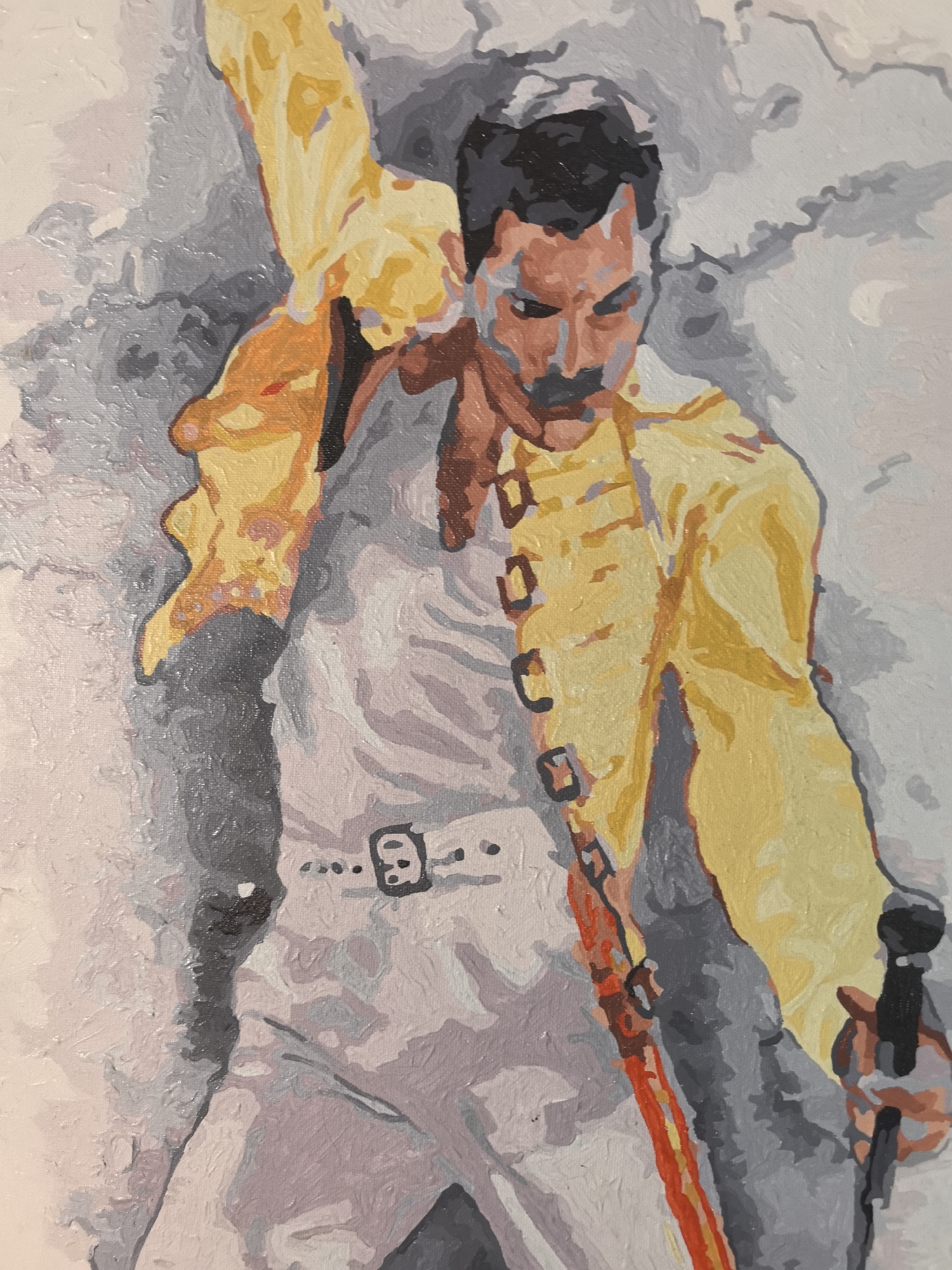 This is a painting of Freddie Mercury, lead singer of the band Queen, in a dynamic pose with one arm raised and holding a microphone in the other. He's wearing his iconic yellow jacket, open to reveal a white outfit with a belt and buckle detail. The background is a mix of gray and white abstract brushstrokes, possibly suggesting a stage or crowd. The painting style is somewhat simple and blocky with distinct color areas, suggesting a "paint by numbers" aesthetic. The location of Noviy, Russia, is not depicted or relevant to the image's content.