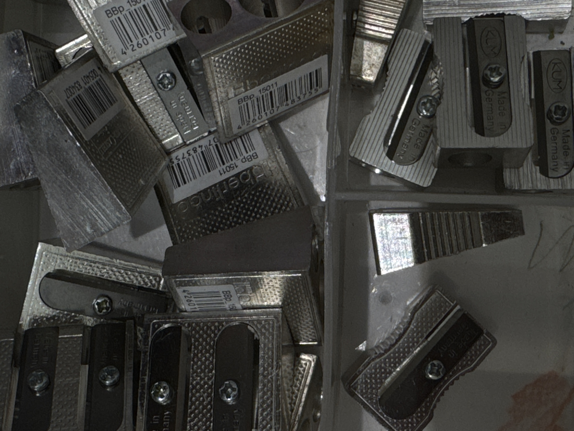The image shows a pile of metal pencil sharpeners. Some of the pencil sharpeners have barcodes and text labels that are partially visible. The text "Made in Germany" is visible on several of the sharpeners. There are no people or any other objects visible in the image. The image does not provide any information about the location in Moscow, Russia.