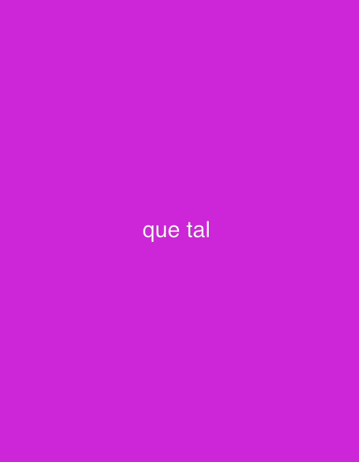 The image displays a minimalist composition featuring a solid, vibrant purple background. Centered horizontally and positioned slightly above the vertical midpoint, the phrase "que tal" is written in white, lowercase, sans-serif text. No people, objects, or a specific scene are depicted beyond this plain background and text. There is no activity taking place, as the image is static and text-based. Notable details such as time of day, weather, or specific location cues are absent from the visual content. The text "que tal" translates from Spanish to "how are you" or "what's up." The overall tone is simple and direct, focusing entirely on the textual message against the stark, colorful backdrop.