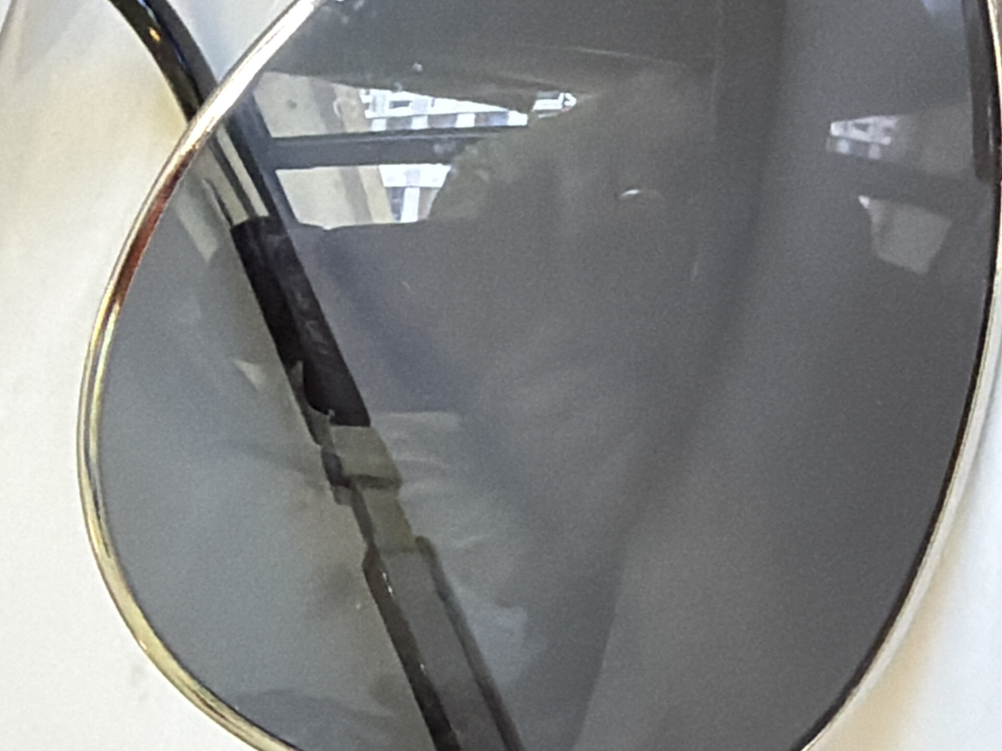 The image shows a close-up of sunglasses reflecting a building. The reflections suggest a modern building with windows, possibly located in an urban area. Without additional information, specifying the location in Budva, Montenegro, or providing further details about the reflected scene is impossible.