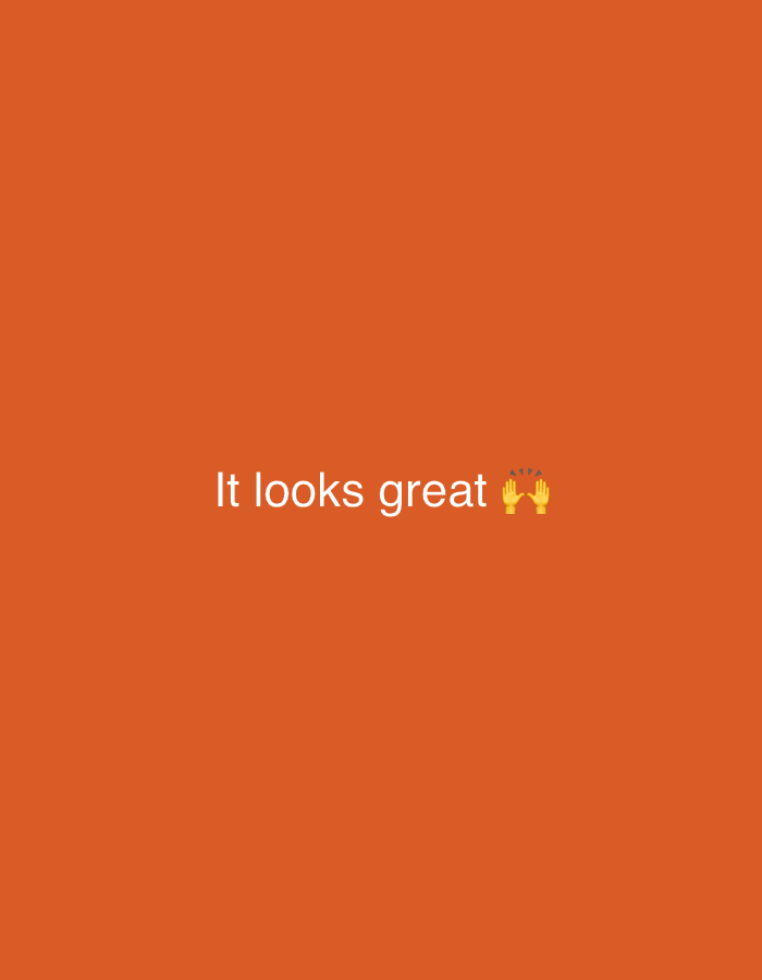 The image is a screenshot from a digital device, displaying a plain orange background. White text reads "It looks great" followed by a high-five emoji. The image is not in Sochi, Russia.