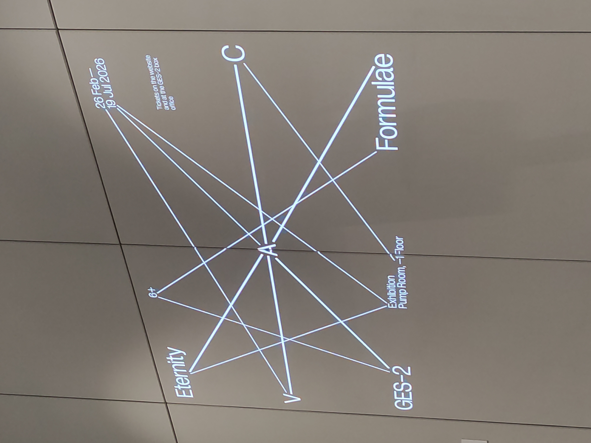 Here is a description of the image:
The image shows an advertisement for an exhibition titled "Formulae". The poster features a diagram that connects various elements: the exhibition title, the words "Eternity", the age restriction "6+", the date "26 Feb - 19 Jul 2026", information about ticket availability on the website and at the GES-2 box office, the location "GES-2 Exhibition Pump Room, -1 Floor", and the letters "C" and "V"