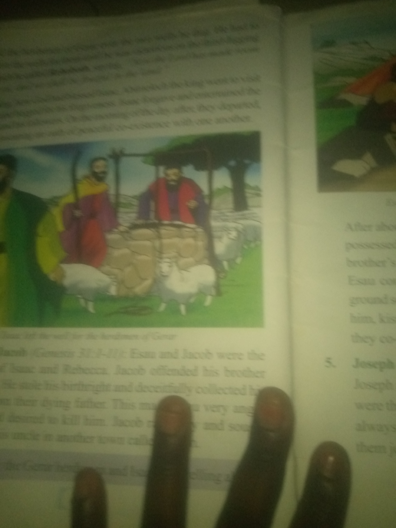 The image displays an open book with text and an illustration. The illustration depicts three figures near a stone well with sheep. The text discusses biblical figures and events, mentioning Jacob, Esau, Isaac, Rebecca, and Joseph, and referencing Genesis. The image also shows parts of a person's fingers in the foreground, obscuring some of the text. The text on the right side of the page contains numbered points, with "5. Joseph" visible. There is no visible information or context that places the image in Jauro Yinu, Nigeria.
