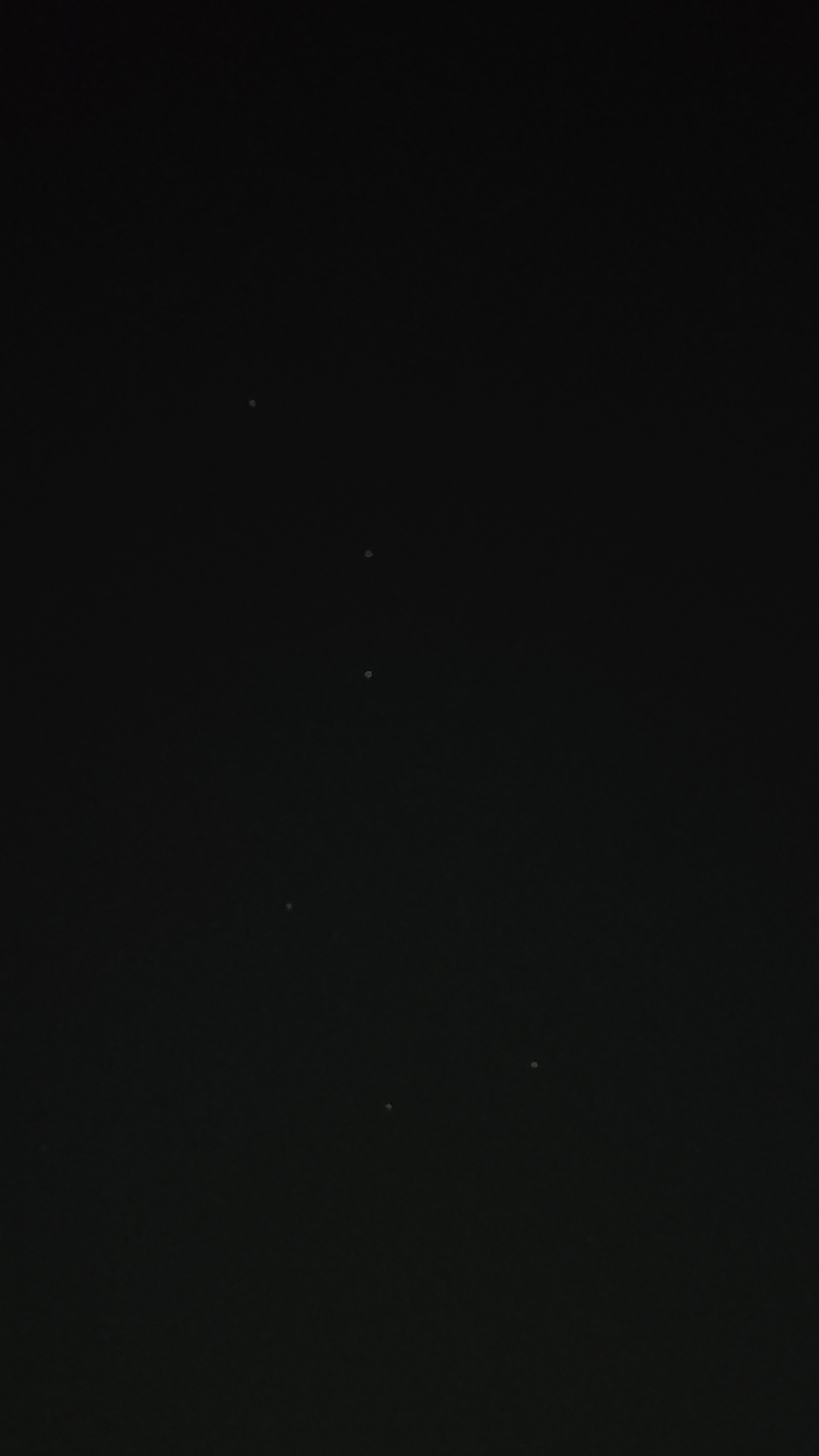 The image displays a dark, black background with several small, faint white dots scattered across it. These dots are likely stars or distant lights. The overall impression is that of a night sky with a limited number of visible celestial bodies or artificial lights. There are no discernible cityscapes, buildings, or specific landmarks visible that would allow for precise localization within Sofia, Bulgaria. The image is devoid of any people, subjects, objects, or actions.