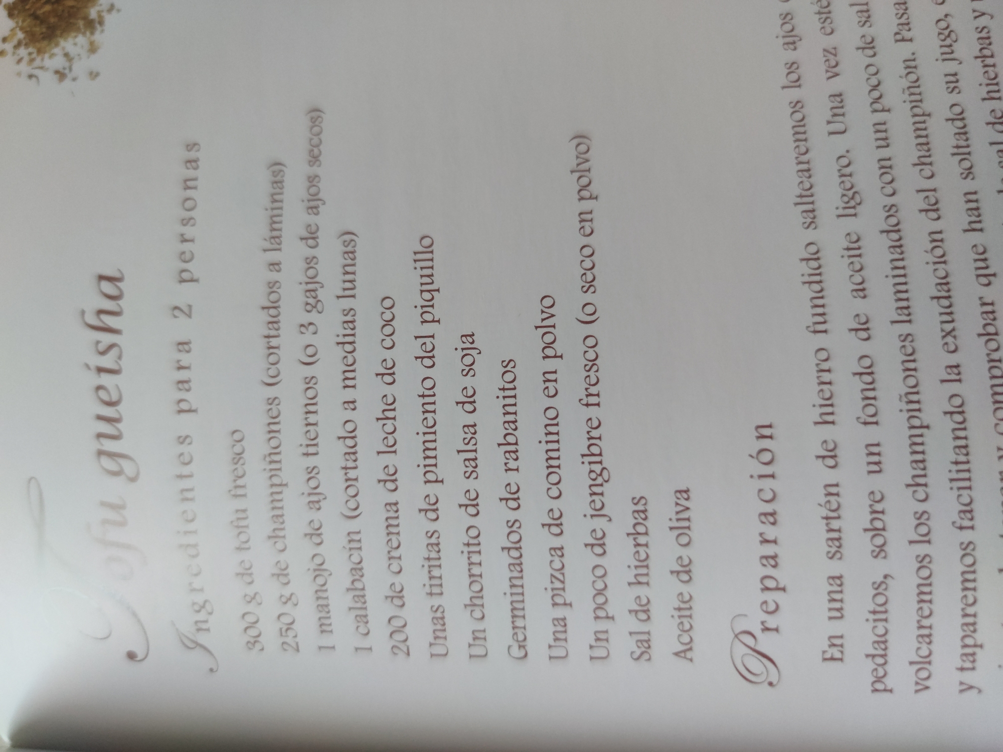 The image shows a page from a cookbook. The title of the recipe is "Tofu Gueisha". The page lists the ingredients required to make the dish for two people, including tofu, mushrooms, garlic, zucchini, coconut cream, piquillo pepper, soy sauce, radish sprouts, cumin powder, ginger, herbal salt, and olive oil. The recipe's preparation instructions are also visible. The text is written in Spanish.
