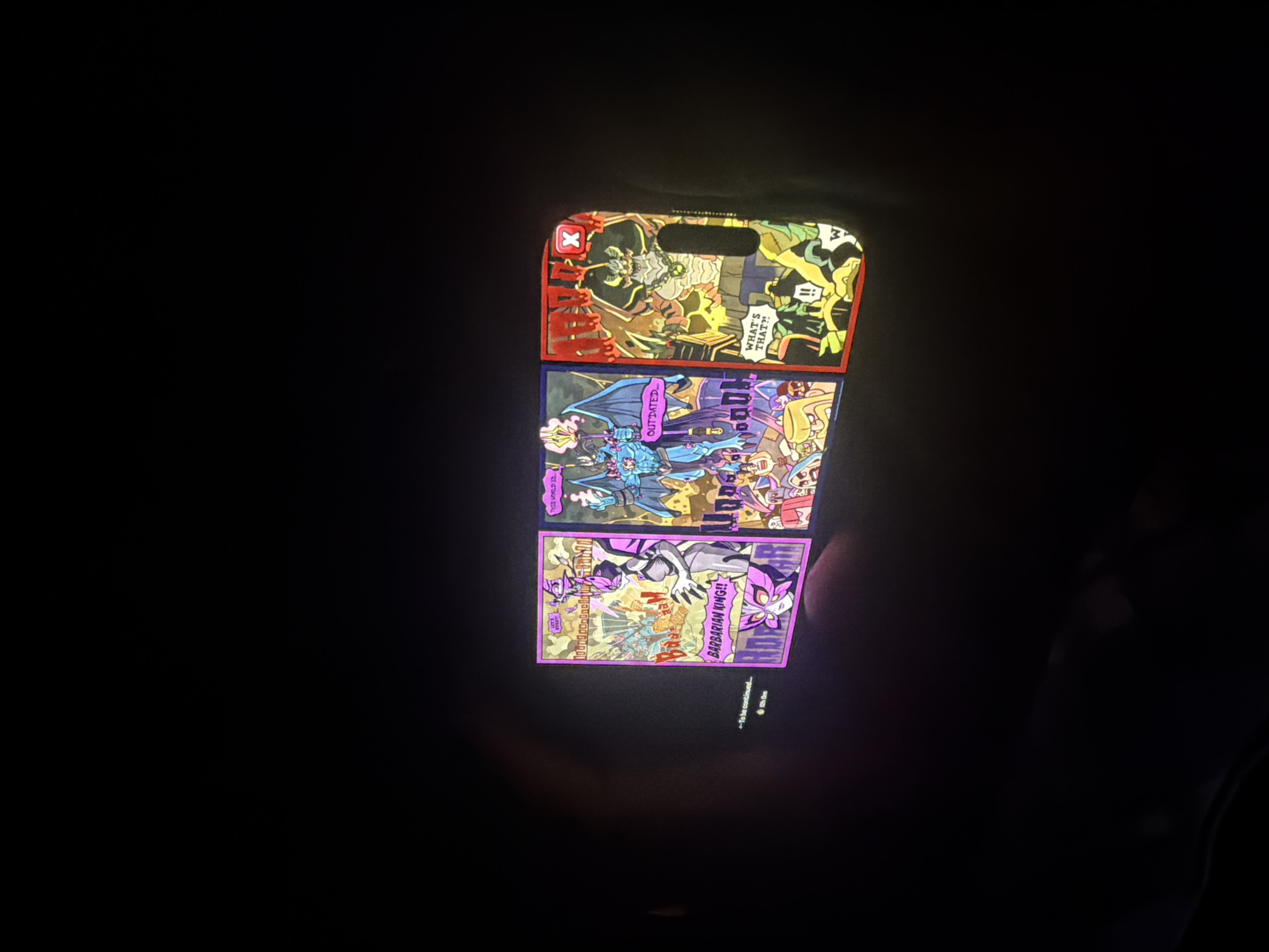 The media file displays three vertically arranged, brightly illuminated rectangular panels against a dark, featureless background, possibly a darkened room with a screen. Each panel features colorful, comic-book style illustrations with distinct themes and characters, resembling game selection screens or character art.
The top panel, bordered in red, shows a green-skinned, tusked creature with chains, resembling an ogre or monster, in a chaotic scene with other cartoon figures and structures. Visible text includes an "X" symbol in a red box and a speech bubble with "WHAT'S THAT?!".
The middle panel, bordered in blue, features a winged, blue-skinned character in a cape wielding a staff, surrounded by fantastical elements and creatures. Partial text "OUTDATED" and "DOOM" can be seen.
The bottom panel, bordered in purple, depicts a dynamic scene with a purple-clad, clawed character identified by the text "BARBARIAN KING!!". Other text visible includes "BATTLE" and "KINGDOM" on a background structure. Below this panel, faint text reads "TO BE CONTINUED..." and "10h 10m", suggesting a video game or animated series context for the displayed content.
The overall scene conveys a sense of vibrant, action-oriented fantasy art presented in a digital or illuminated physical format against a dim backdrop.