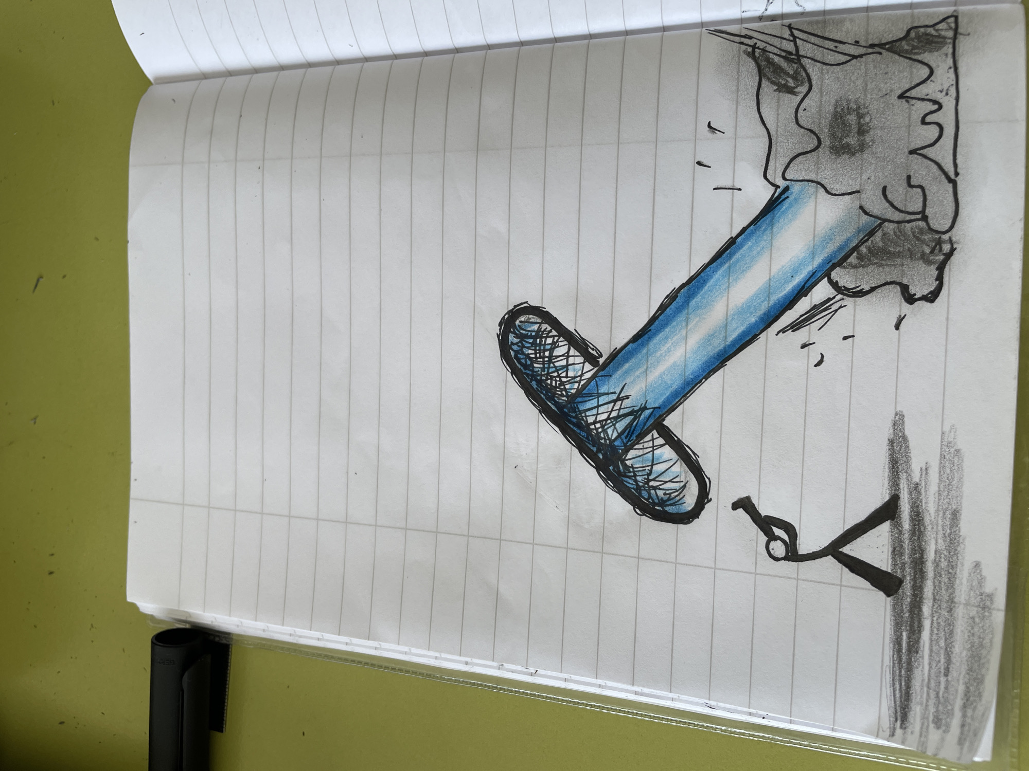 A sketch on lined notebook paper shows a large, blue-tinted beam of light emanating from a dark, amorphous shape at the upper right of the page. The beam points diagonally downward and left to a dark, rounded shape with a cross-hatched pattern inside. Below this, and to the right, is a small, crude drawing of a person being attacked by a large dark shape that is dripping downwards. The notebook lies open on a solid, light green surface. A black object is also on the solid green surface. The scene is not from Zlatograd, Bulgaria, and there is no evidence of a specific location.