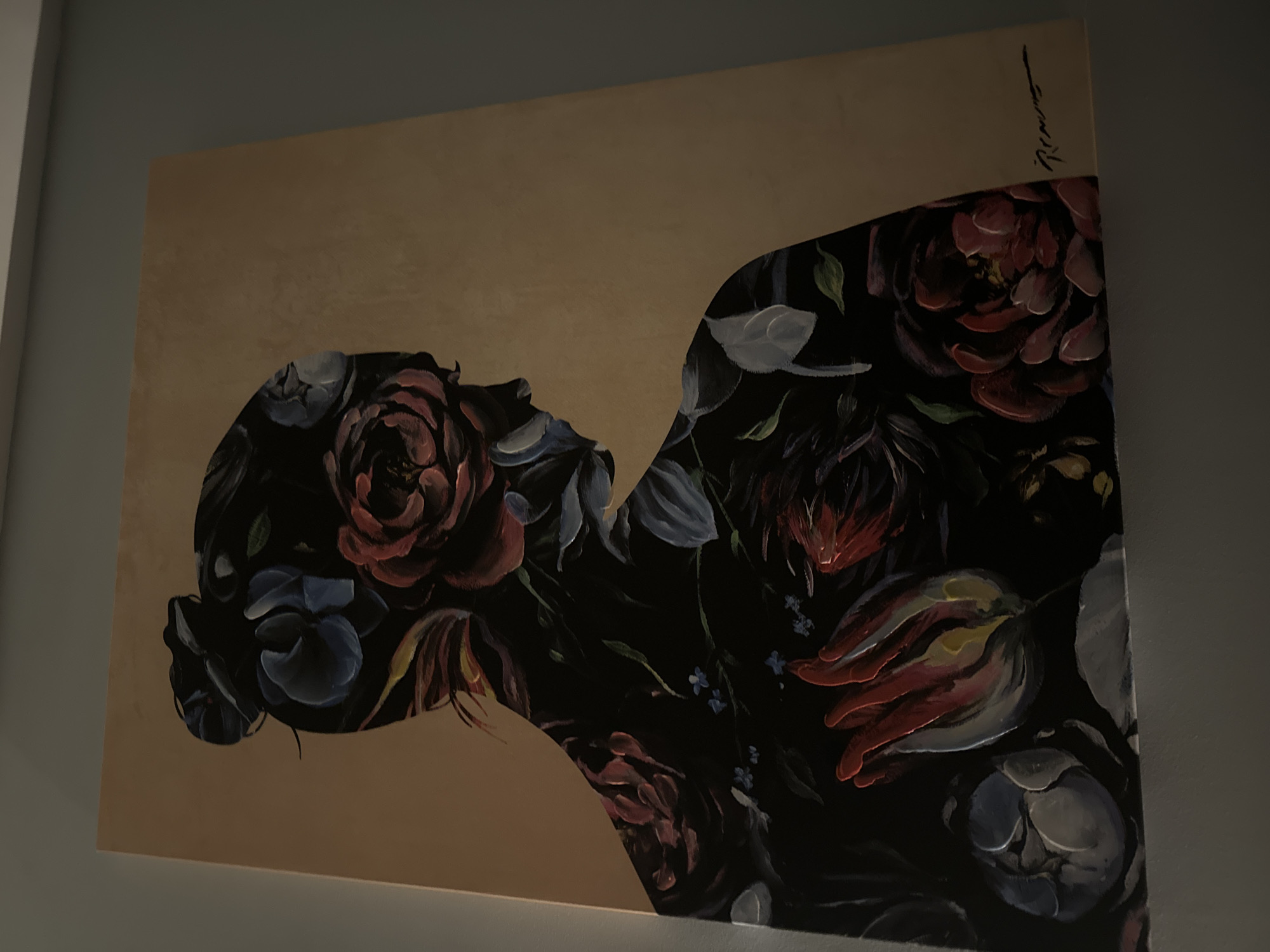 The image shows a painting hanging on a wall. The painting depicts a silhouette of a person's head and upper torso, filled with floral patterns in shades of red, blue, and grey, set against a beige background. The signature is visible in the upper right corner. The painting appears to be indoors, adjacent to a grey wall. The city of Sofia, Bulgaria, is not evident in the image.