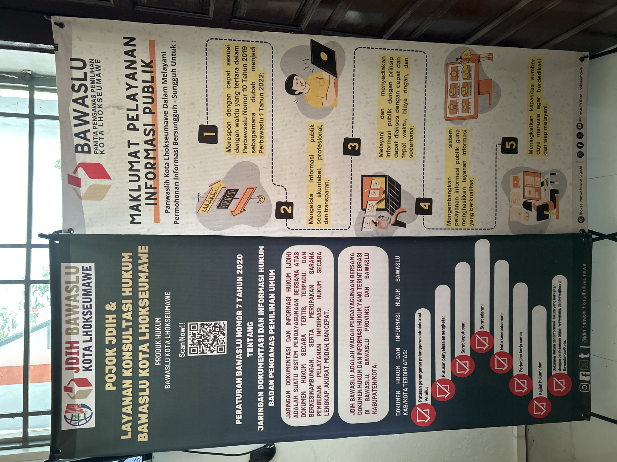 The image shows a banner for the Jaringan Dokumentasi dan Informasi Hukum (JDIH) Bawaslu Kota Lhokseumawe, which translates to the Network of Documentation and Legal Information of the Election Supervisory Agency of Lhokseumawe City. The banner is displayed in the city of Lhokseumawe, Indonesia. The banner is split into two sections: the left side, in black, contains information about the JDIH, including its function and the types of legal documents it contains; the right side, in white, outlines the commitment to public information services, including responding quickly, managing information transparently, providing accessible information, developing service systems, and increasing human resource capacity. The banner features the Bawaslu logo and contact information. There are also QR codes available to scan.