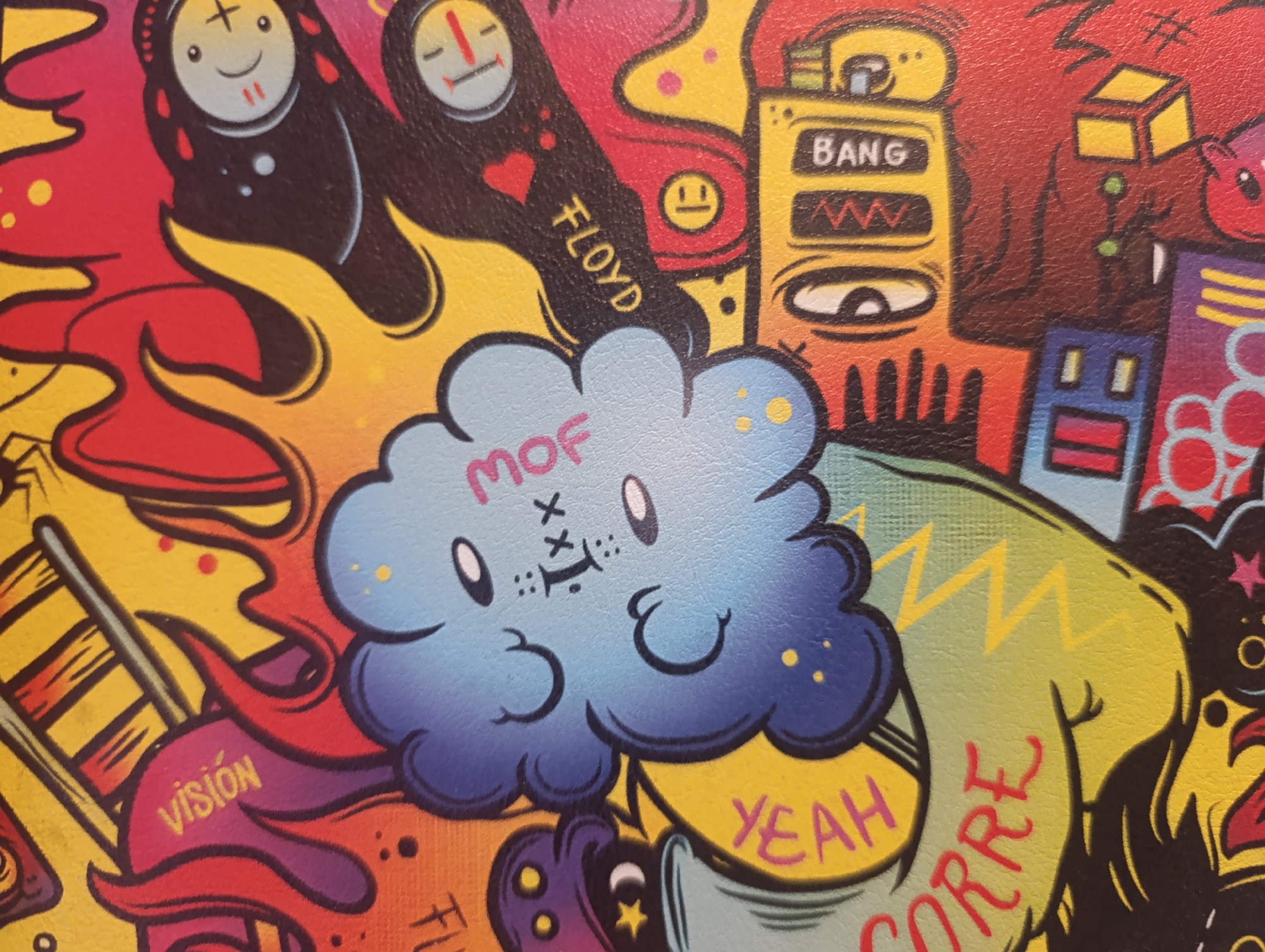The image is a close-up of a graffiti-style mural. The mural features a mix of cartoon-like characters, abstract shapes, and text. A central element is a light blue cloud-shaped character with the letters "MOF" above its face, which has an "X" for each eye and a horizontal line for its mouth. To the left of the cloud is a figure with a plus sign in each eye and a smiling mouth. Next to it is a figure with a minus sign in each eye and a horizontal line for its mouth. Next to it is the word FLOYD, with the O as a smiling face and a heart above the Y. To the right is a yellow object with the word BANG on it. Below the cloud, the word YEAH is written in pink. A green arm-like shape has the word CORRE written in red on it. To the left of the cloud, the word VISION is written in yellow. The mural utilizes a vibrant color palette, including reds, yellows, blues, greens, and oranges. There is no information in the image to confirm its location in Зипуново, Russia.