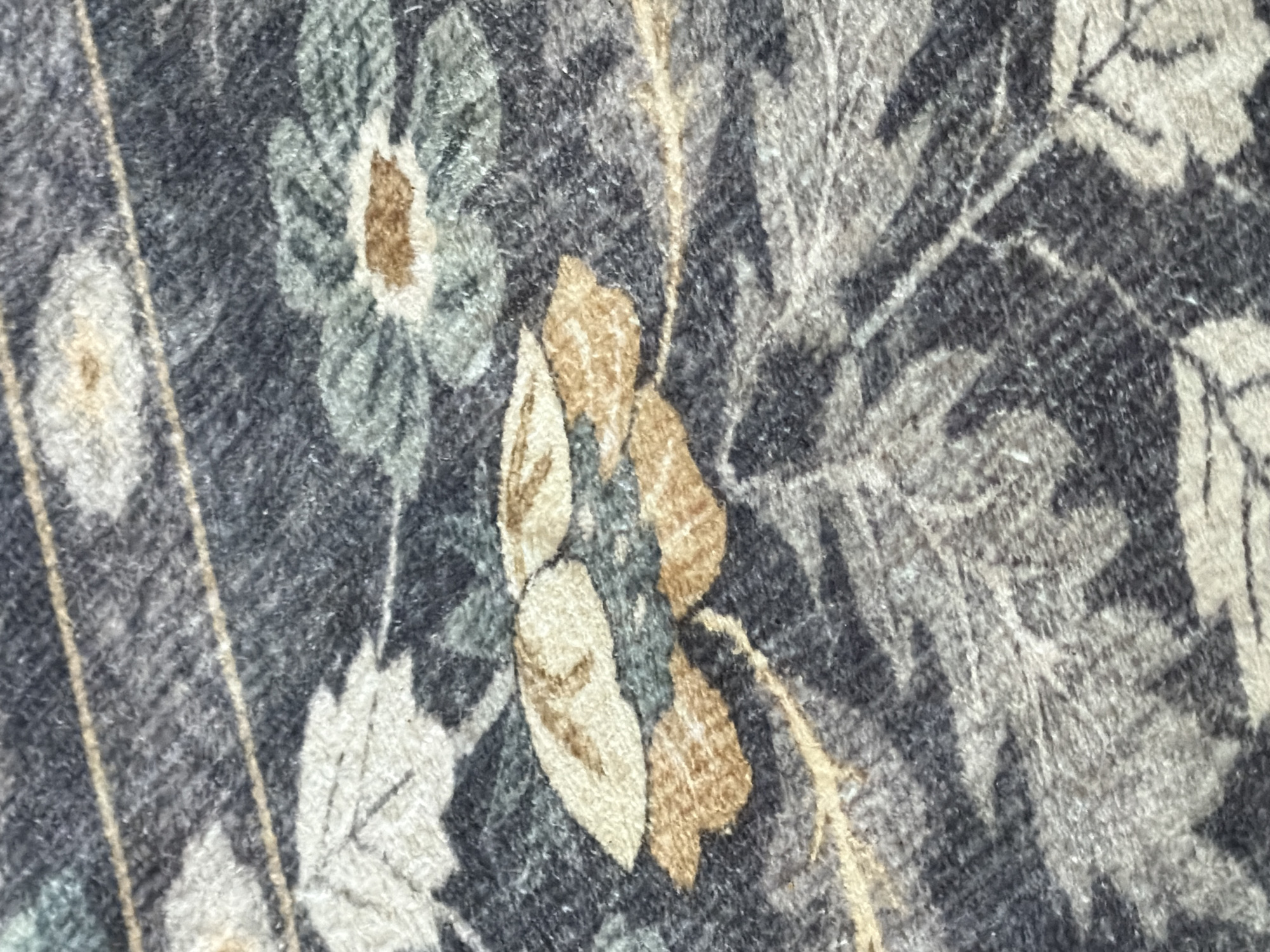 The image shows a close-up of a floral patterned fabric or material. The colors are muted, with shades of grey, beige, brown, and hints of green. The pattern consists of stylized floral and leaf shapes with defined line work. There are no people visible in the image. Location information (Ramat Gan, Israel) is not detectable from the visual information in this image.