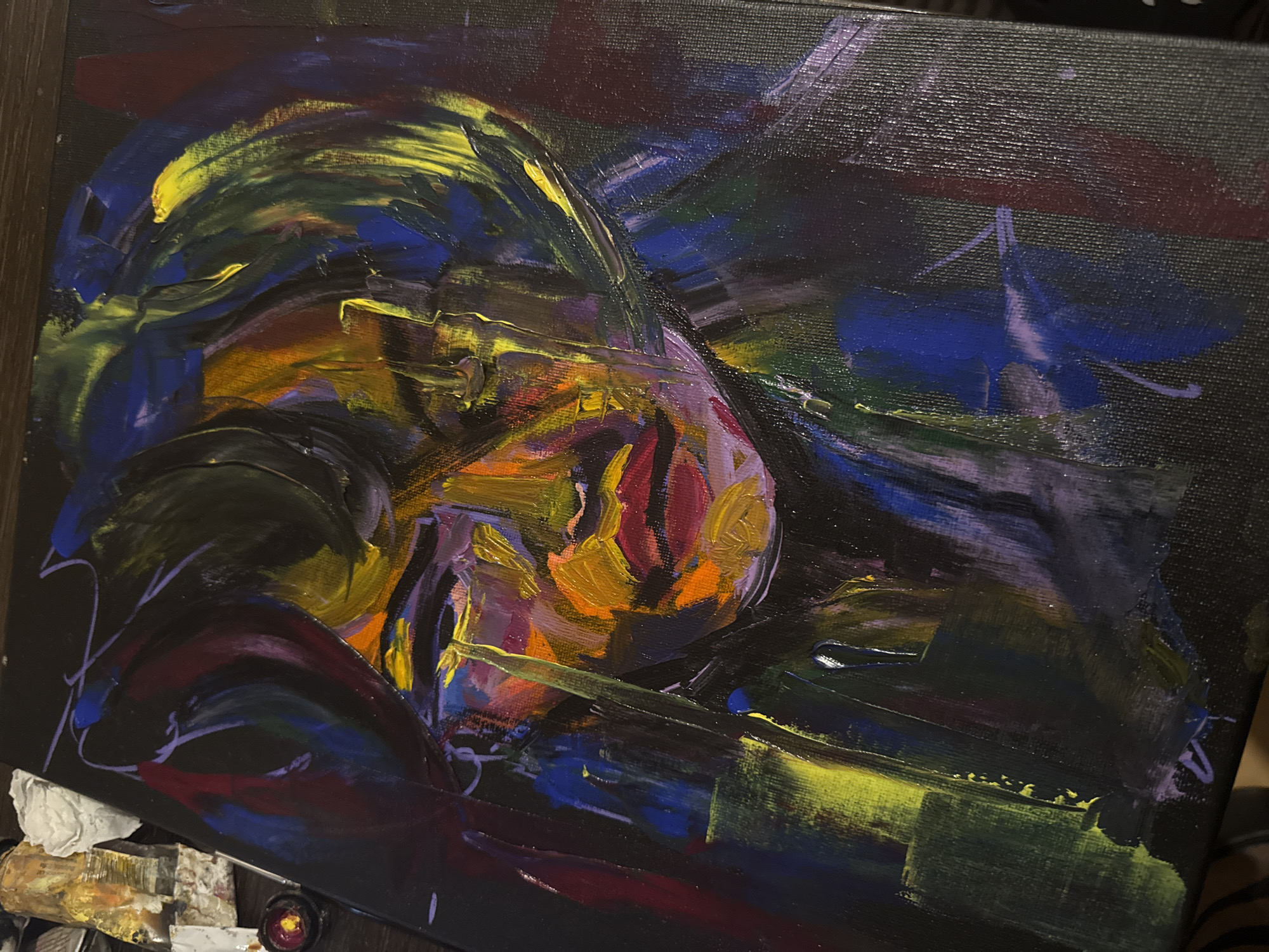 The image shows an abstract painting with heavy brushstrokes and a dark background. Dominant colors include yellows, oranges, blues, and purples. The subject is indistinct but appears to be a figure or landscape interpreted in an expressionistic style. There is no evidence to indicate the painting is located in Sofia, Bulgaria, or any other specific location.