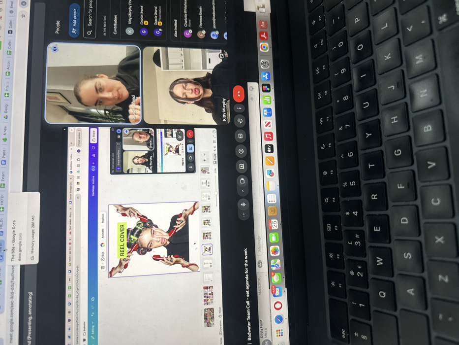 An indoor scene depicts a partial view of a silver/space gray laptop, focusing on its screen and a portion of its black QWERTY keyboard. The precise location within Wealden, United Kingdom, is not discernible from the image.
The laptop screen displays a complex multi-application environment. The primary visible application, on the left, is a Canva design interface featuring a digital artwork. This artwork depicts a female figure with hair curlers, multiple hands (some with wrists appearing as red high heels, others with red-painted fingernails) holding various objects, and a prominent green text overlay stating "REEL COVER." Below this main design, a row of smaller thumbnail previews is visible.
To the right, a Google Meet video conference is active. The largest video feed at the top right features "Gracie Urand," a woman with dark hair wearing a black top, actively speaking and gesturing. Below this, a smaller grid includes a video feed of "Kitty Murphy," also with dark hair and wearing a black top, displaying a distinct facial expression with pursed lips and narrowed eyes. Further to the right, a "People" sidebar lists attendees and invitees, including "Kitty Murphy," "Gracie Urand," Charlotte Whitehead, and Florence Unwin, implying a "Badwater" team meeting.
The top of the screen displays multiple browser tabs, including one labeled "The bite - Google Docs." The bottom of the screen reveals a macOS-like dock with numerous application icons, such as Mail (showing 34,303 unread messages) and Calendar (displaying 26 notifications). Text indicating "Badwater Team Call - set agenda for the week" is visible, along with a partial iMessage window from "Olivia Hirst" dated "18/01/2026." The physical laptop keyboard in the foreground shows some wear on frequently used keys.