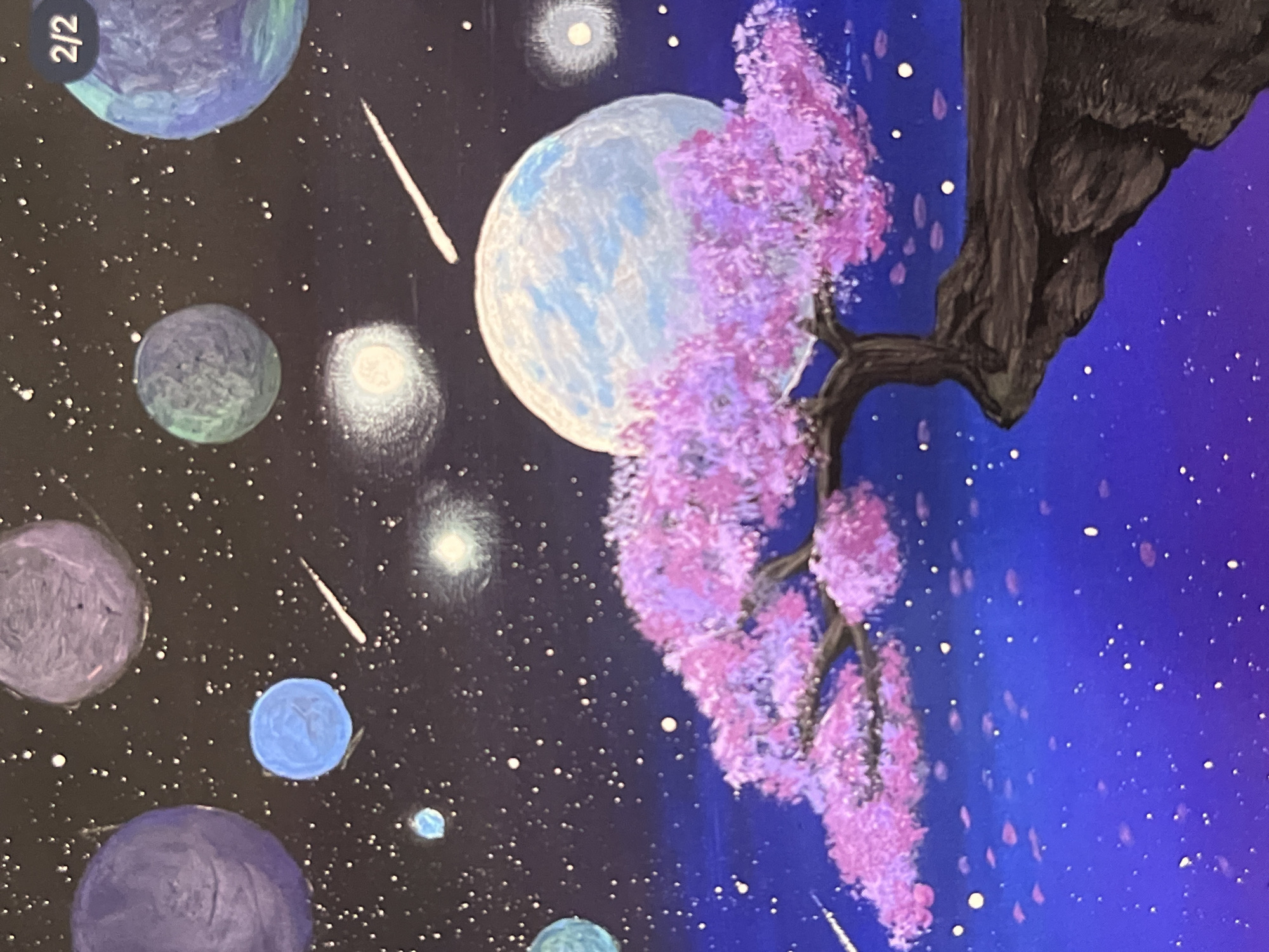 The image is a painting depicting a space scene with various celestial bodies. There are several planets in the painting, rendered in shades of blue, purple, and green, with some appearing to have visible surface features. Streaks of light suggesting comets or meteors are also present. A large, primarily white planet, possibly a moon, is prominently displayed in the center.
A dark, textured tree trunk and branches are positioned on the right side of the image. The branches are adorned with pink blossoms, resembling a cherry blossom tree. The background transitions from a dark, star-filled space on the left to a brighter blue hue on the right, with stars scattered throughout. There is no location information provided for Unknown, Indonesia.