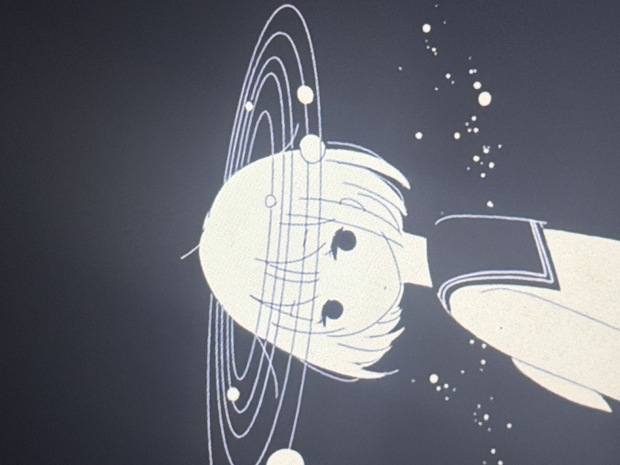 This is a digital illustration with a dark background that appears to depict a stylized anime-style girl with short, light-colored hair. She is wearing a school uniform with a dark collar and trim. Around her head, there is a ring with several smaller circles, resembling a planetary system. Scattered across the background are numerous small white dots, which could represent stars or dust. The overall aesthetic is minimalist and monochromatic, primarily in shades of white and dark gray. There is no discernible location in Ursoaia, Moldova, as this is a digital artwork.