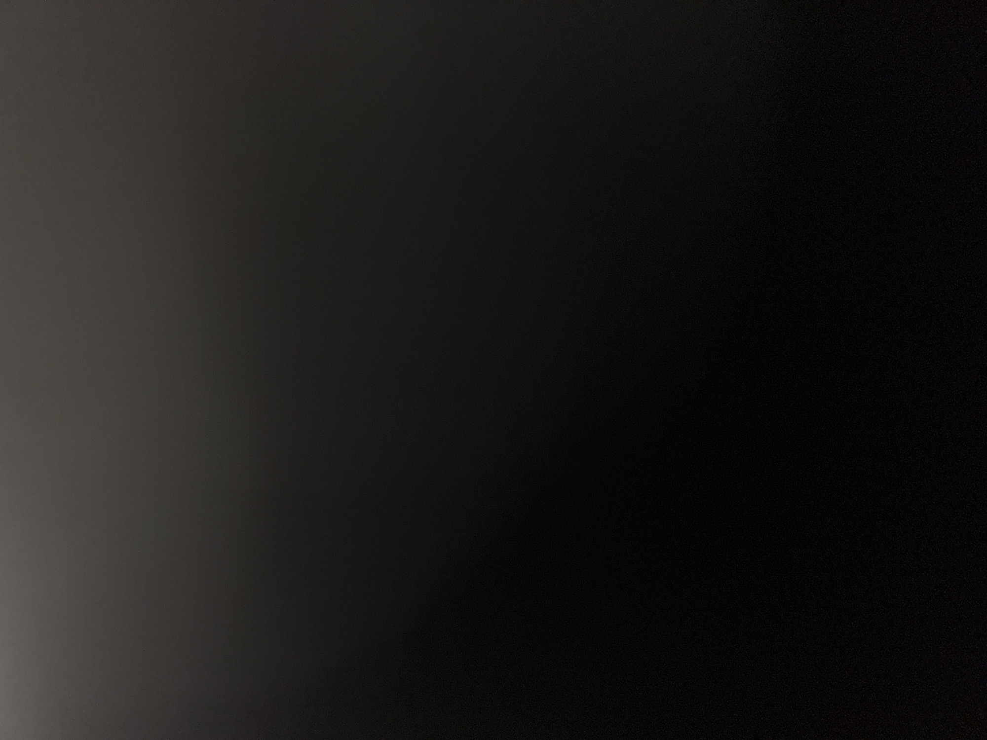 The image is a dimly lit or dark indoor scene. There are no identifiable subjects, objects, people, or actions visible. The lighting is uneven, with a gradient of darkness from right to left. There's no discernible information to locate the scene in Ihiagwa, Nigeria.