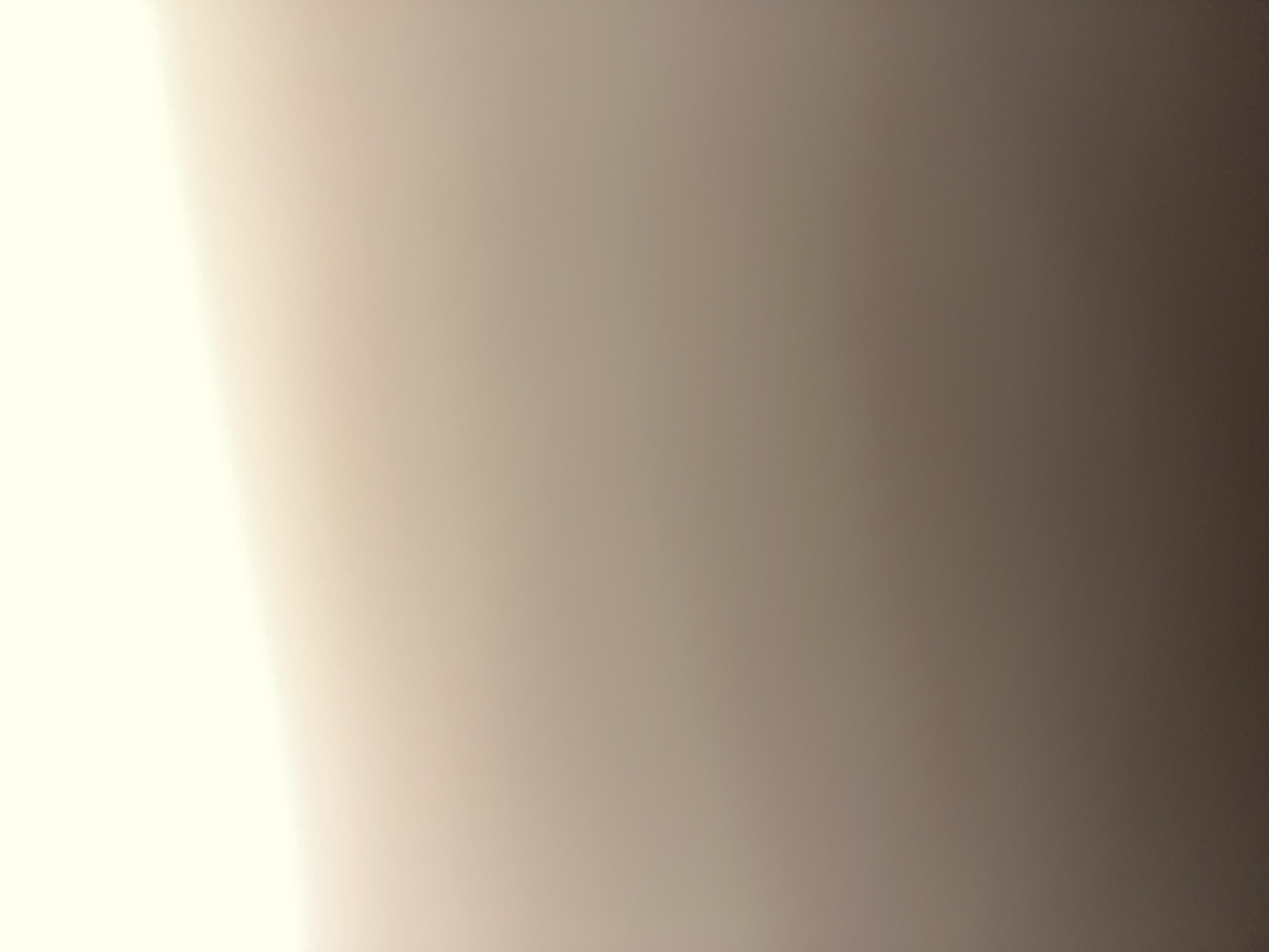 The image depicts an abstract and out-of-focus scene with a gradient of light colors, ranging from a bright, creamy white at the top to a muted brown at the bottom. There are no discernible objects, people, or actions visible in the image, suggesting it may be a deliberate abstract composition or a result of poor focus or lighting. It is impossible to determine the location within the city of Mozhaisk, Russia, or any other details due to the lack of concrete visual information.
