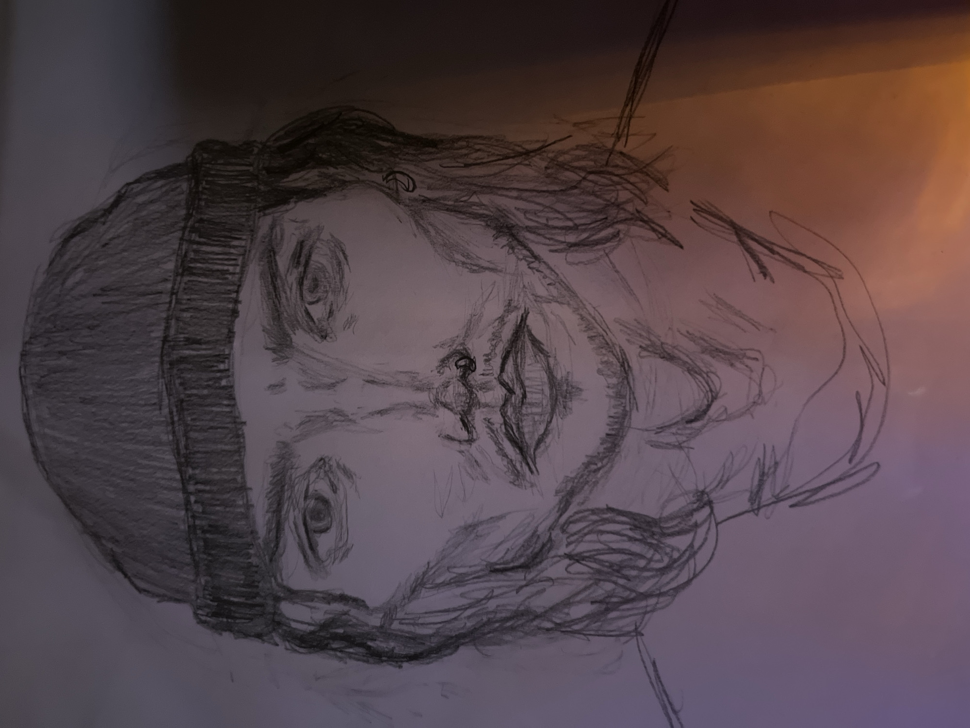 The image is a pencil sketch of a person's face, viewed from the front. The subject is wearing a beanie and has long, wavy hair. They have a nose ring and an earring. The sketch is rendered with loose, expressive lines, giving it a somewhat raw and unfinished quality. The background is a gradient of soft purple and orange light. There is no discernible location in Kazan, Russia, or any specific environmental details that can be identified. The focus is entirely on the sketched portrait.