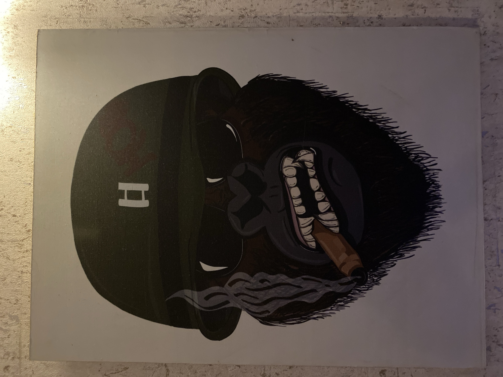 This is a painting of a gorilla wearing a military helmet and sunglasses, smoking a cigar. The gorilla has a fierce expression, with its teeth bared. Smoke is rising from the cigar and curling around the gorilla's face. The background is plain white. The painting appears to be unframed and is hung on a textured wall, possibly made of concrete or stucco, with visible brushstrokes or a rough finish. The lighting suggests an indoor setting. The image does not depict any specific location in Giginyu, Nigeria.