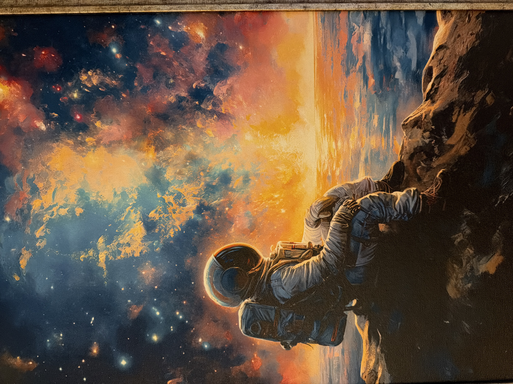The image is a painting of an astronaut clinging to a rock formation. The background consists of a colorful nebula-like space scene with stars. The astronaut is wearing a spacesuit with a helmet. A planet is visible in the background behind the astronaut. The painting has a textured surface.