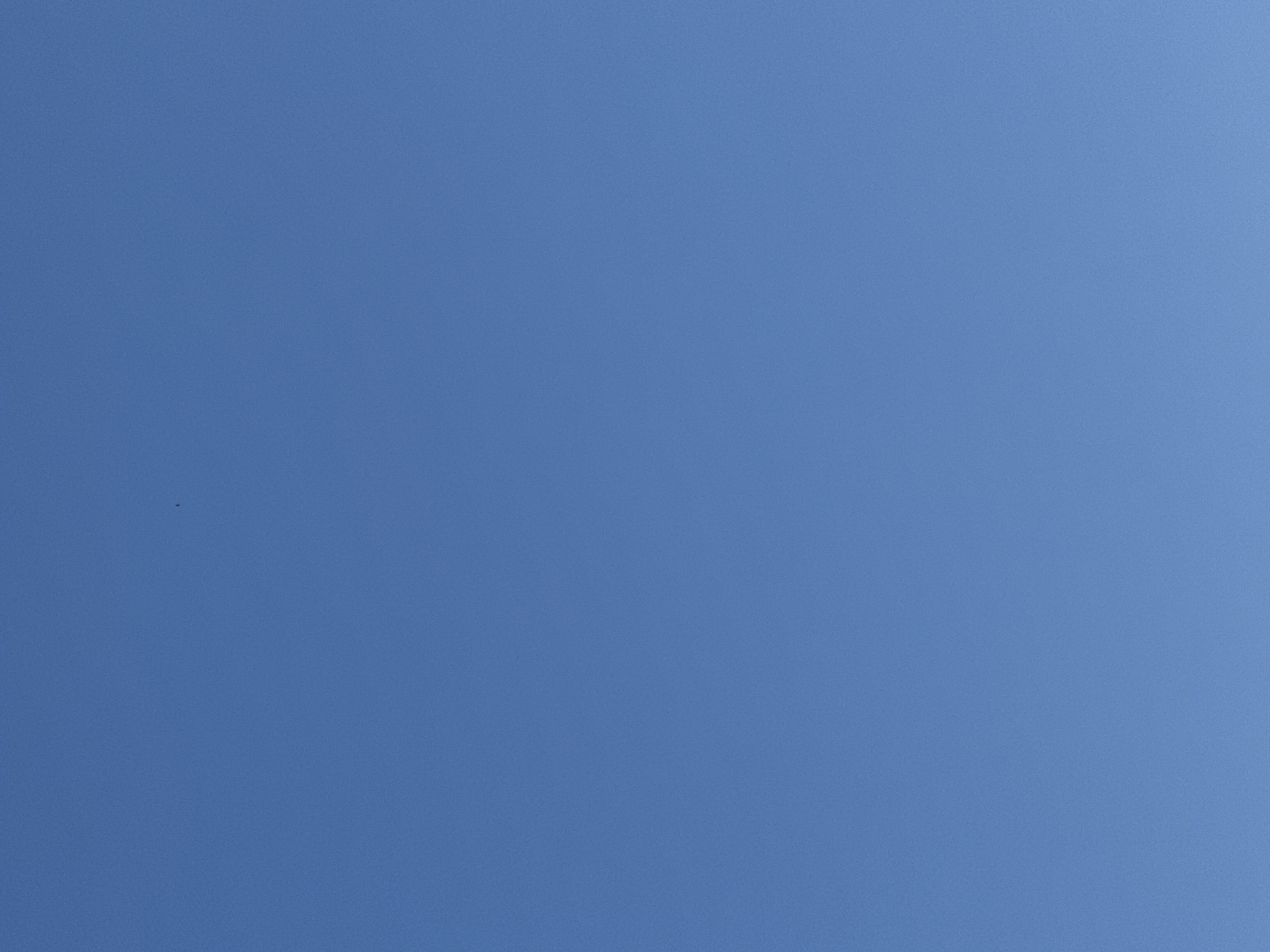 The media file is a photograph of a clear blue sky. There are no discernible subjects like people or objects, and the scene is an abstract expanse of blue. The activity, if any, is not visible. Notable details include the clear, cloudless sky, suggesting fair weather during the daytime. There are no specific location cues, and no emotions are conveyed. There is no visible text in the image. The image is a simple, unadorned shot of the sky.