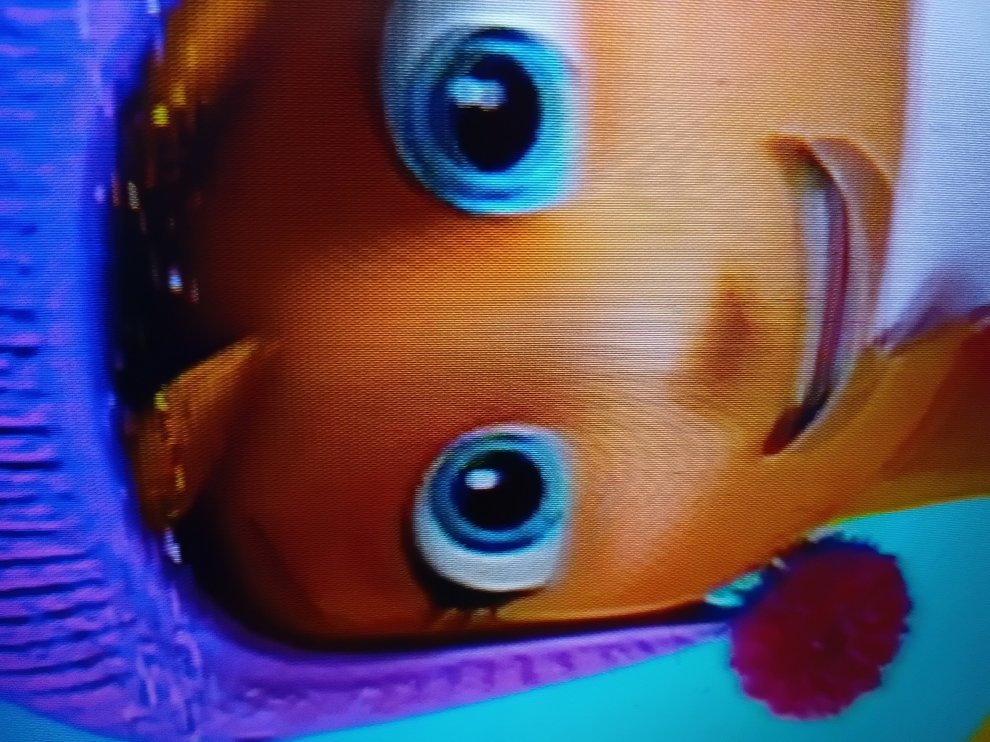 A close-up, digital image shows the face of a cartoon character wearing a purple knitted hat with a blue pom-pom accent and a light blue neck warmer. The character has large, blue eyes with black pupils and thick black eyelashes. The character's skin is a warm orange hue, and a hint of a smile is visible. The background is a solid, bright teal color. The image is pixelated, suggesting it was captured from a screen.