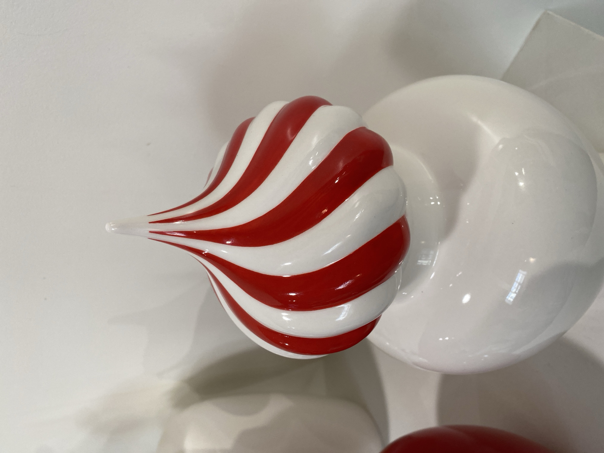 A close-up shot of a red and white striped, candy-shaped ornament, situated next to a larger, white, circular object. The objects are positioned on a white surface. There is no other identifiable context in the image to support any reference to Moscow, Russia.
