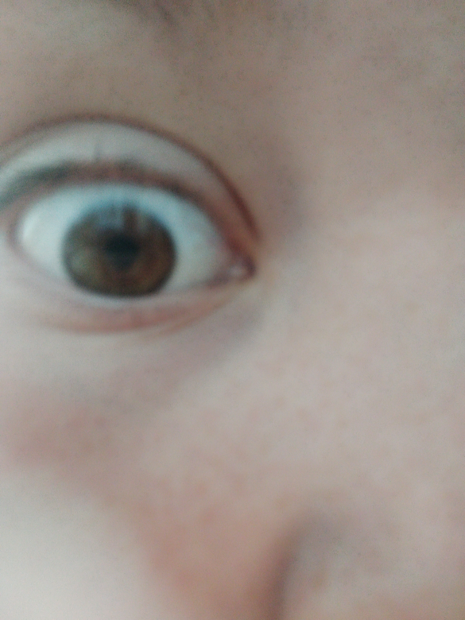 A close-up, blurry photograph shows a human eye. The iris is brown and the pupil is black. The eyebrow is visible above the eye. Skin texture is visible on the surrounding area of the face. The image does not provide information to determine the location as Odesa, Ukraine.