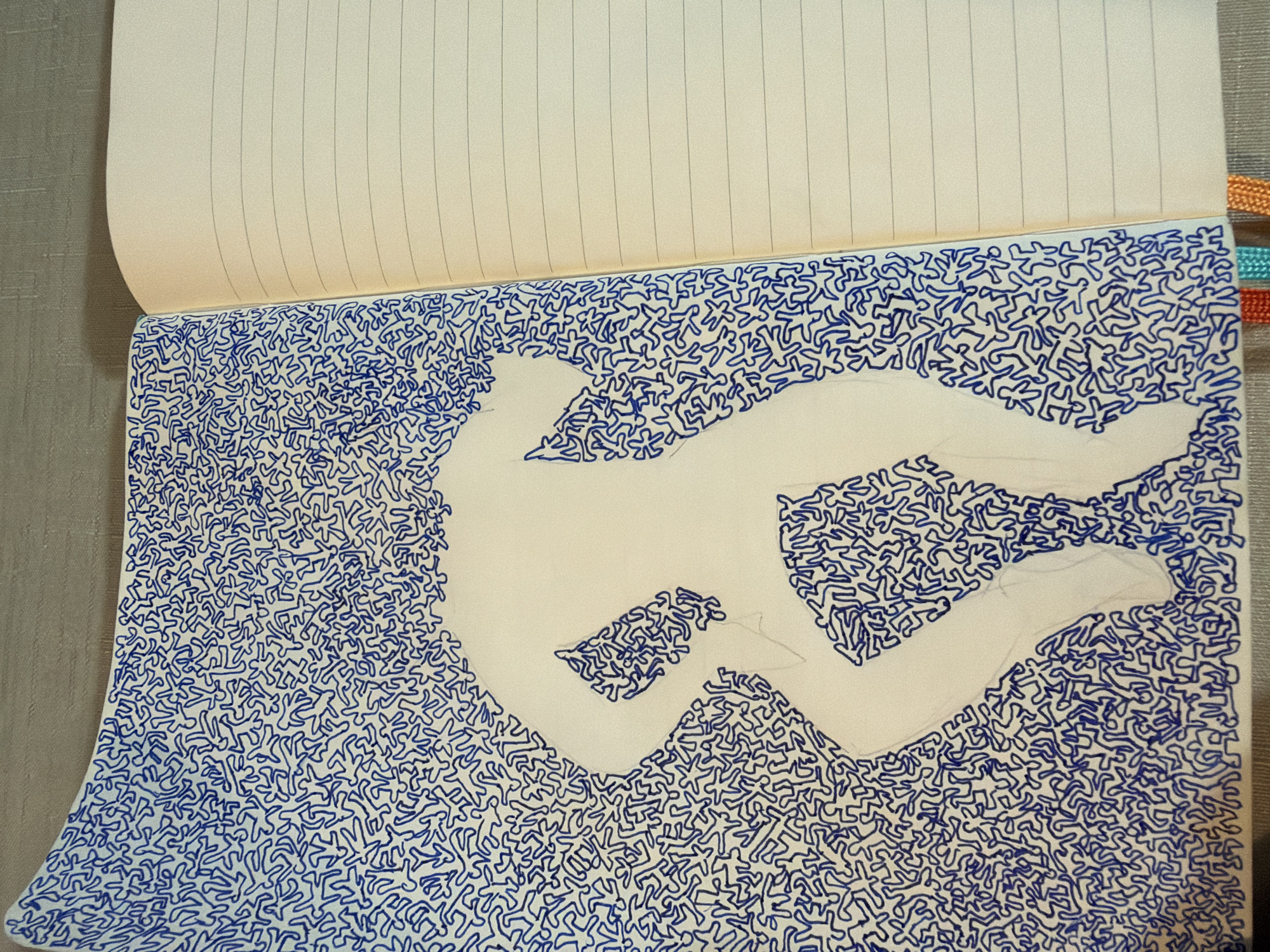 The image shows an open notebook with a drawing on the left page and blank lined pages on the right. The drawing on the left page is rendered in blue ink and depicts a silhouetted figure in a dynamic pose, possibly dancing or in motion. The figure is outlined, and the space around it is filled with a dense pattern of small, interconnected blue stick-figure-like shapes. The right page of the notebook is plain, with faint horizontal lines. The notebook is placed on a textured surface, possibly a table or desk. The background of the image suggests an indoor setting. The image does not contain any elements or information that would allow for the determination of its location in Even Yehuda, Israel.