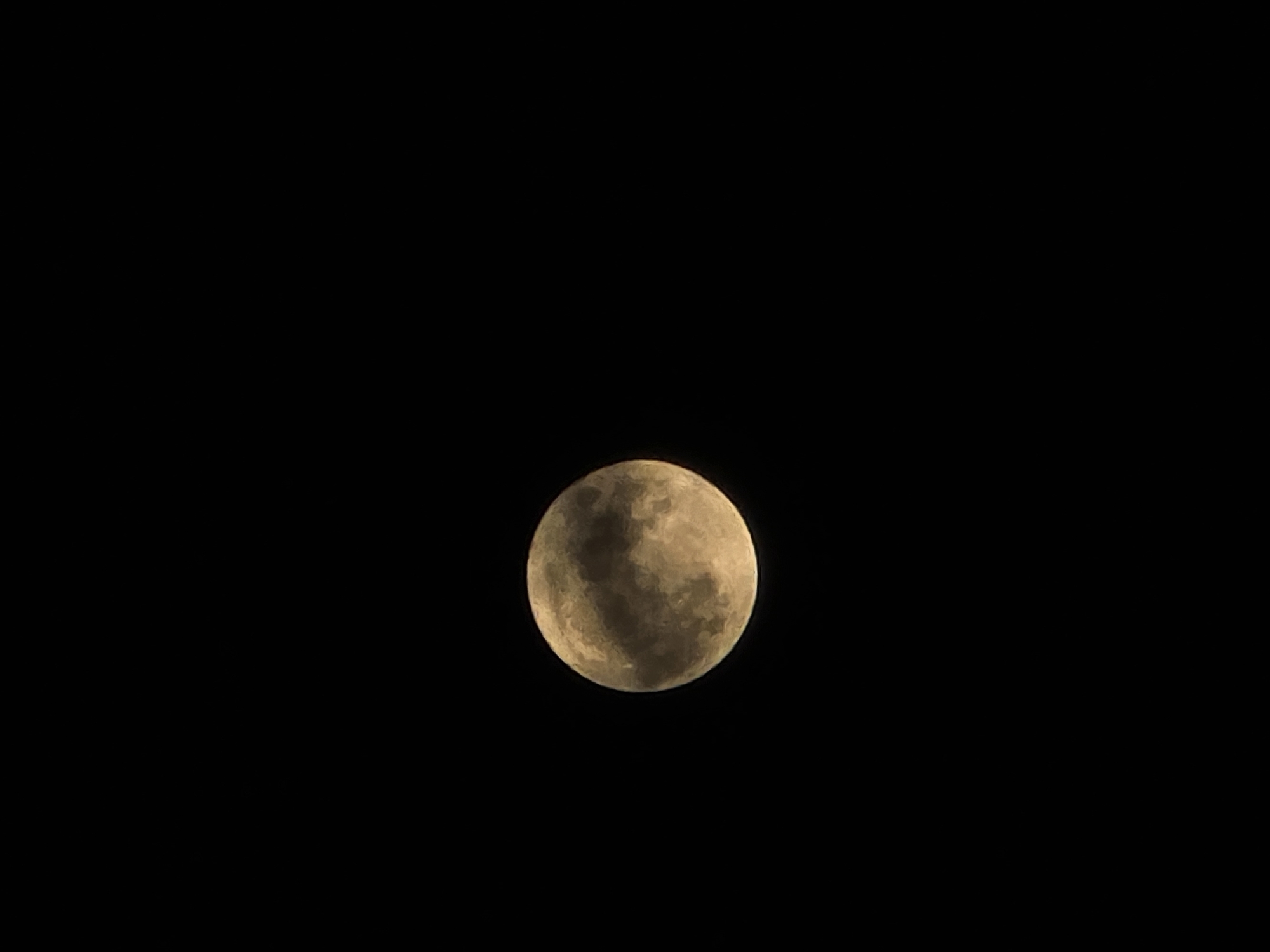 The image shows a full moon against a dark night sky. The moon's surface is visible, with light and dark areas creating a textured appearance. The environment is devoid of any other objects. Burgas, Bulgaria is not identifiable.