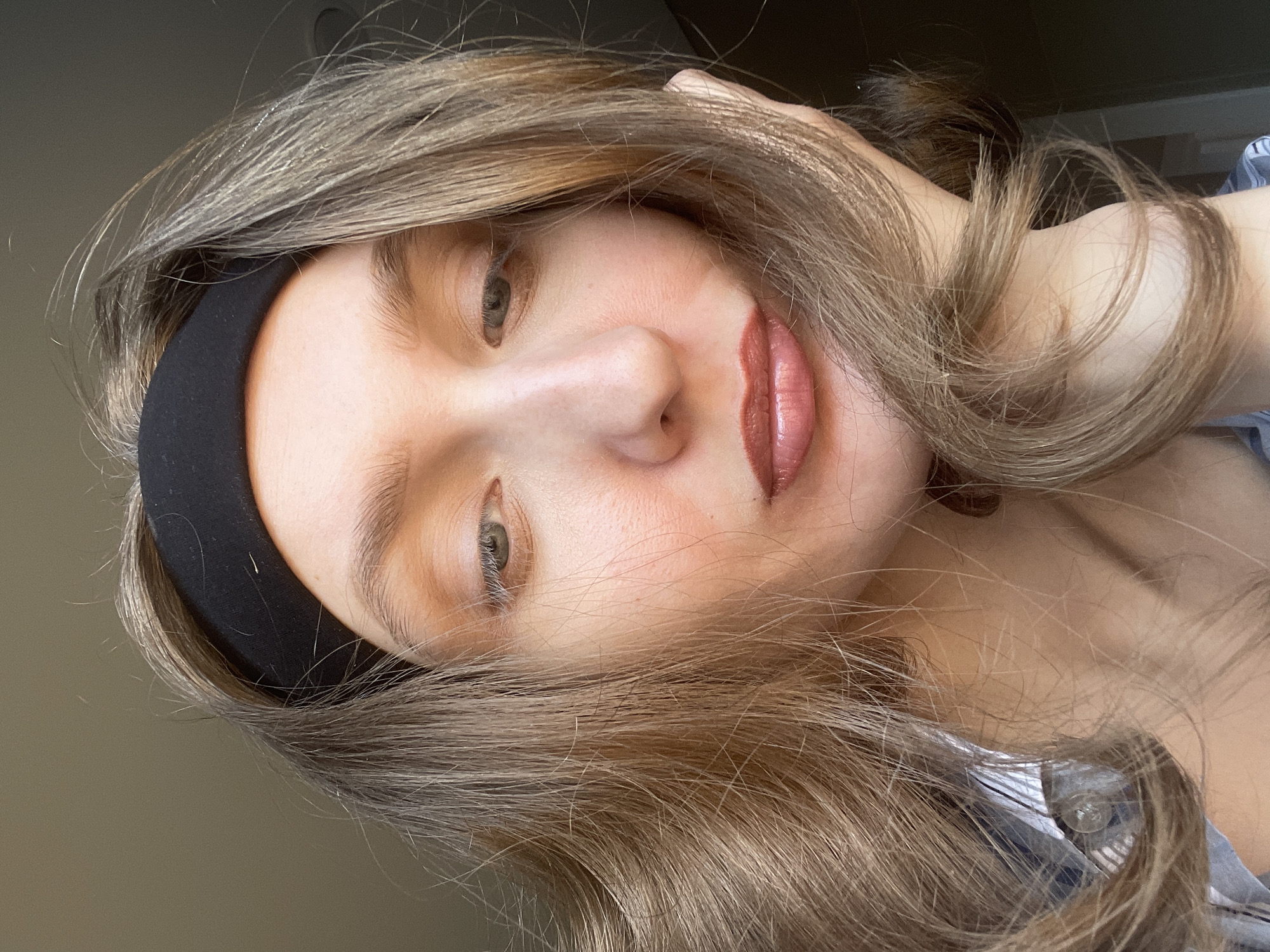A close-up, angled portrait shows a person with fair skin and light brown hair, wearing a black headband. The person's lips are visible and appear to have been made up. The person is wearing a shirt that is partially visible. Based on the available data, the location of the image in Sepych, Russia, is unknown.