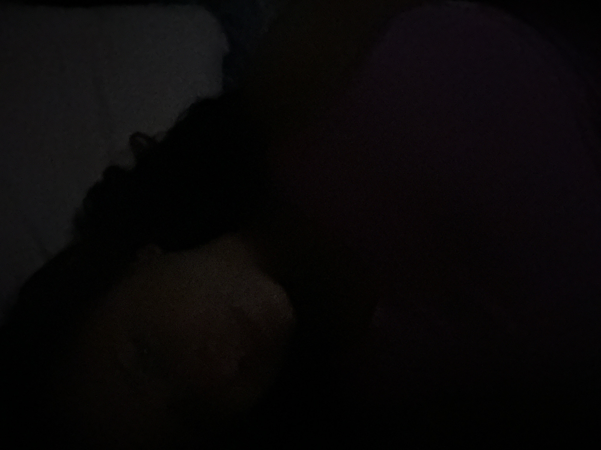 The image is dark, but it appears to show a person lying down on a pillow. There is no indication of the location being London, United Kingdom, or any other city. The surroundings are obscured by darkness.