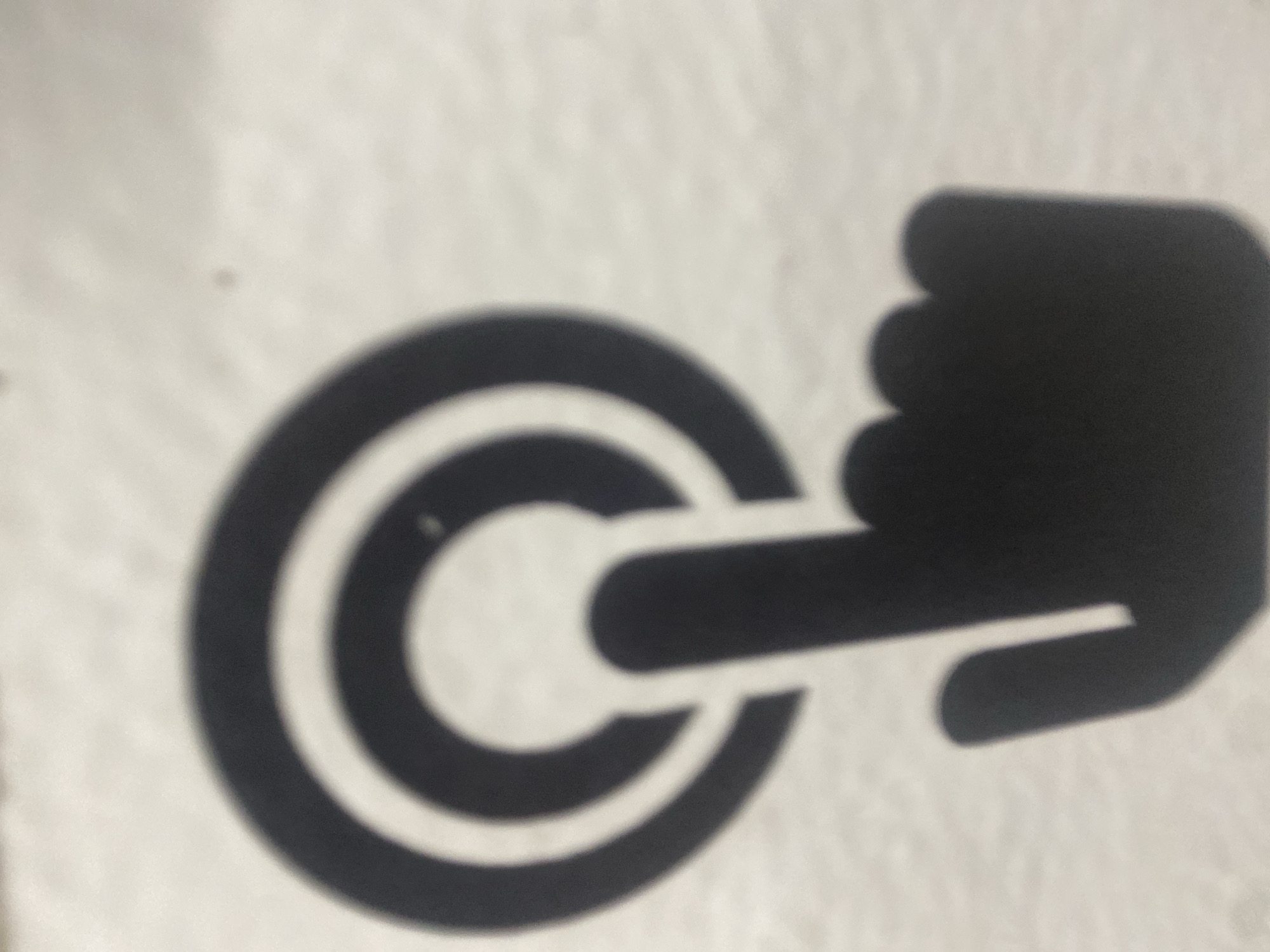 The image shows a black graphic of a hand pushing a button. The button is represented by concentric circles.