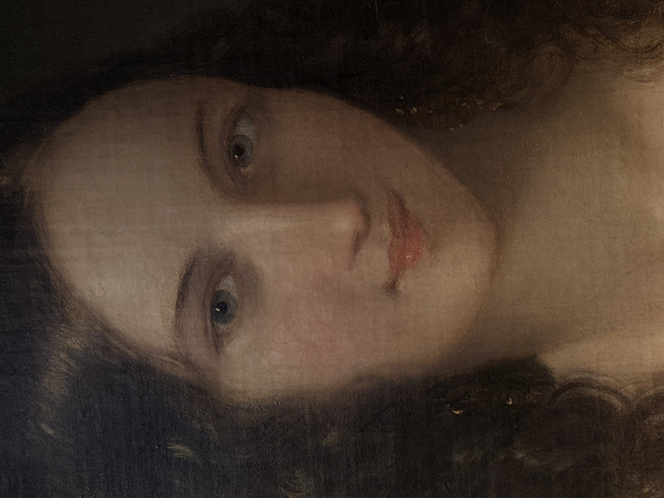 This is a detail of an oil painting on canvas, presenting a close-up portrait of a young woman. The subject has fair skin, dark, voluminous wavy hair framing her face, and blue-grey eyes that gaze slightly upward and to the viewer's left. Her lips are a soft coral red, forming a subtle, closed smile. The background is uniformly dark, creating contrast with the illuminated features of the face. The painting exhibits visible brushstrokes and minor surface irregularities consistent with age and the medium. This artwork is identified as "Portrait of Vittoria Manzoni" by Francesco Hayez, located in the Pinacoteca di Brera in Milan, Italy.