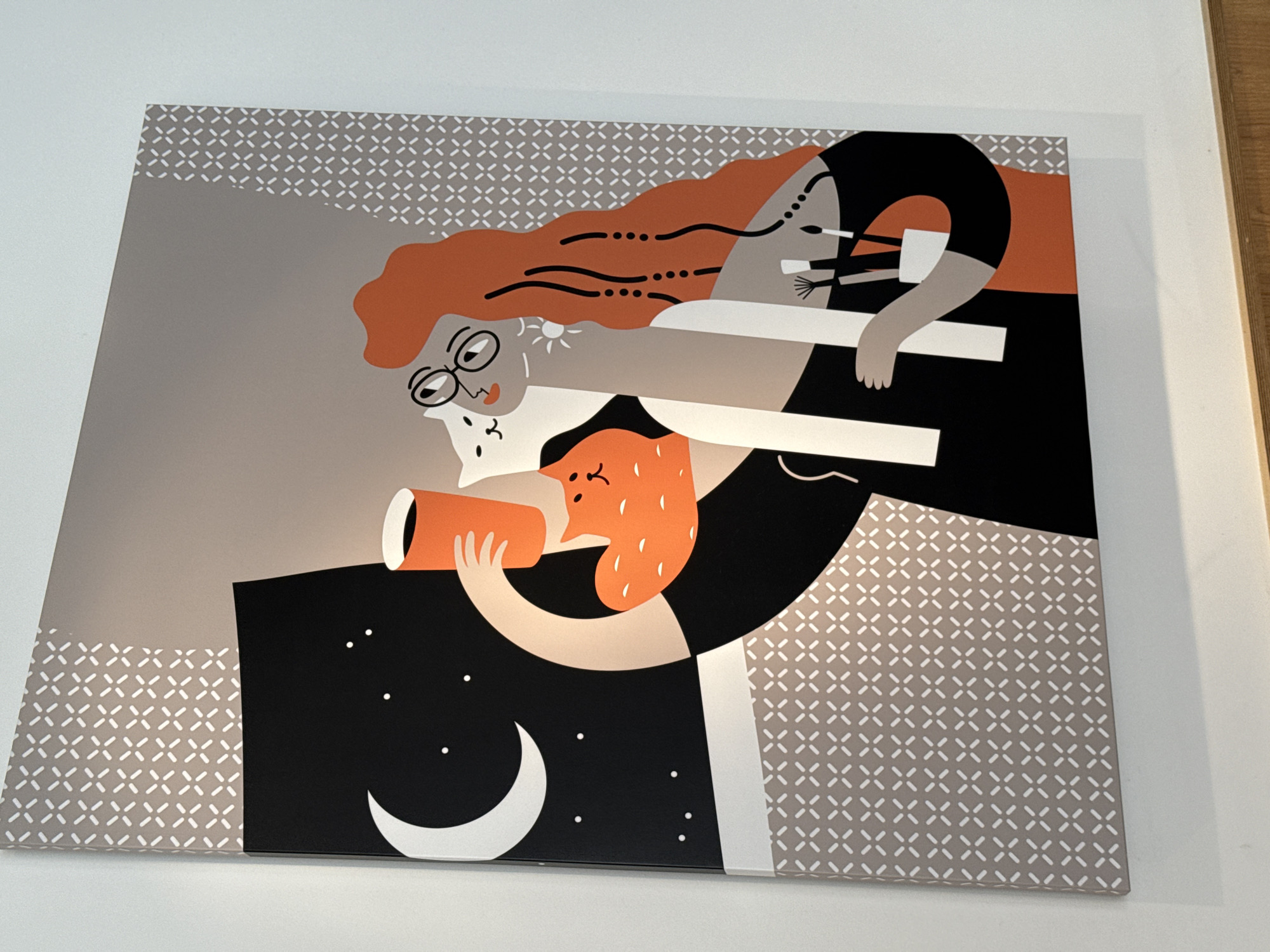 The image shows a framed art print hanging on a white wall. The print depicts an abstract scene featuring stylized human figures and celestial elements. An elderly woman with glasses is looking through a telescope. An orange creature is holding the telescope. A second figure appears to be slumped over in the upper right corner. A black area with white dots representing stars and a crescent moon is in the lower left, suggesting a night sky. The background is a beige and grey pattern. The location in Tobolsk, Russia is not identifiable in the image.