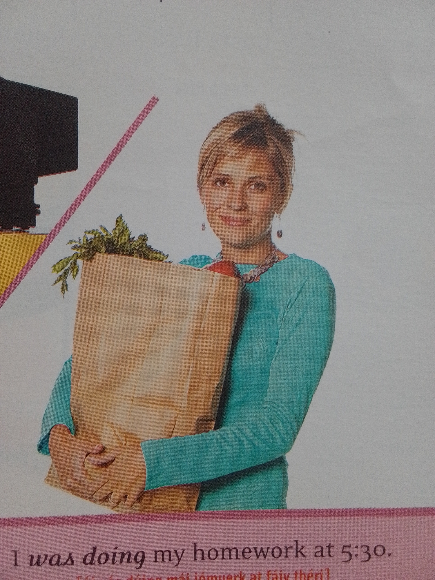 A young Caucasian woman with blonde hair and a light complexion is holding a brown paper grocery bag filled with produce. She is wearing a teal long-sleeved shirt and a necklace. The background is a light gray color with a diagonal pink stripe on the left side and a dark object resembling a monitor. Text is visible at the bottom of the image. This image does not depict La Tagua, Venezuela.