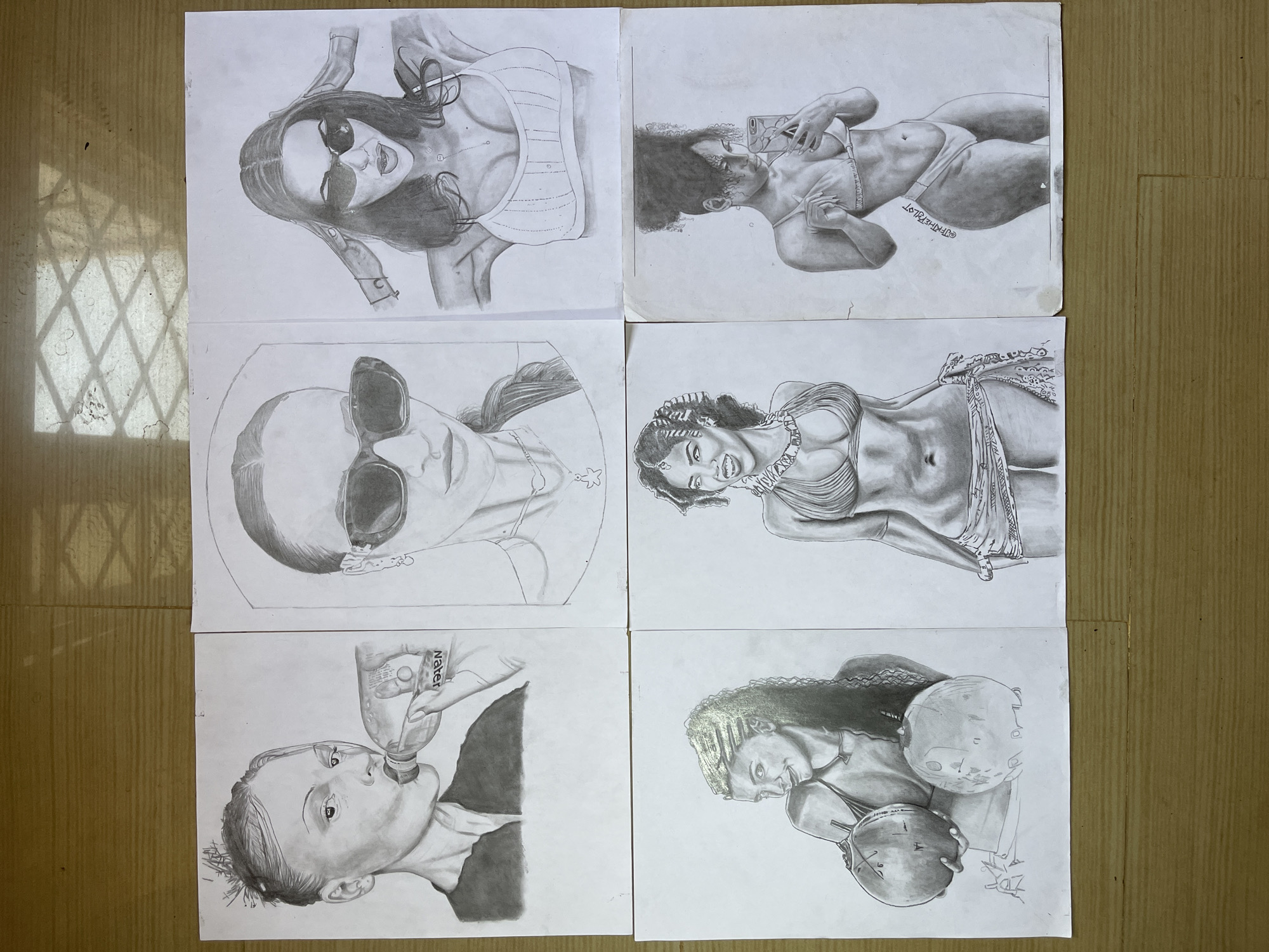 Six sheets of white paper with pencil drawings are arranged on a brown surface. The drawings include: a woman with sunglasses in a top, a woman taking a selfie in a bikini, a woman with sunglasses and braided hair, a woman in a bikini with a necklace, a person drinking from a water bottle, and a woman in a bikini holding two coconuts. The location is Jos, Nigeria.