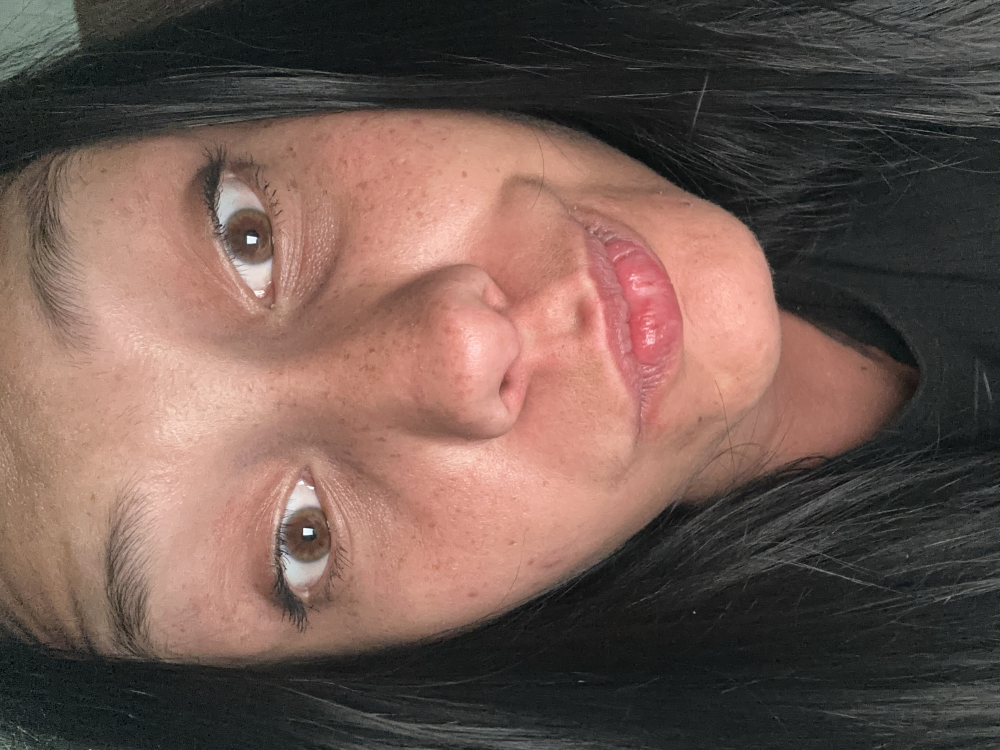 A close-up, slightly blurred, angled portrait of a person with brown eyes, dark hair, freckled skin, and full lips. The person's face dominates the frame, and they are looking directly at the viewer. Their hair surrounds their face. There are no indications of the location being Sofia, Bulgaria.