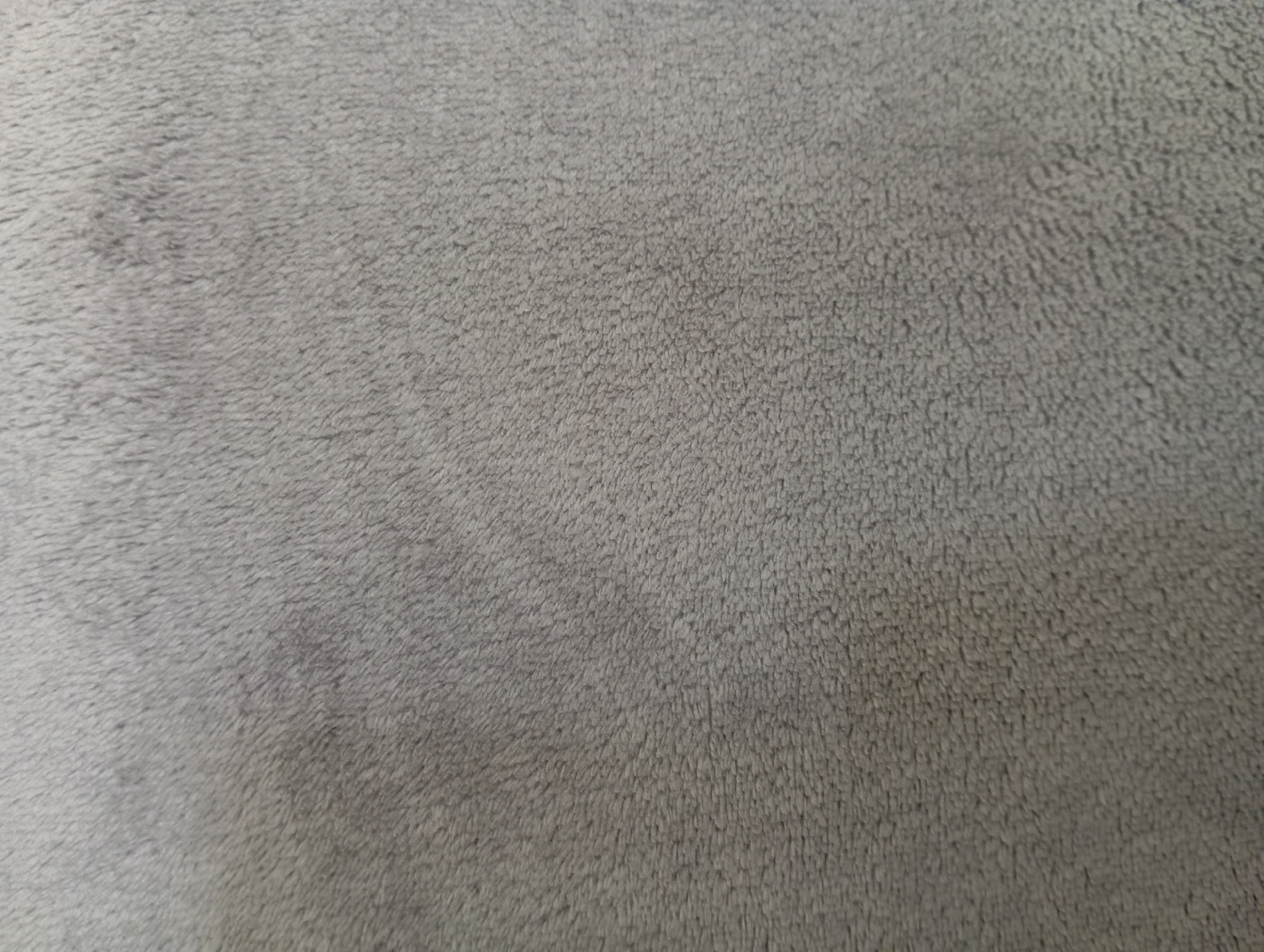The image displays a close-up view of a gray, fuzzy fabric. There are no people, objects, actions, or interactions visible. The texture appears soft and plush, with a uniform color throughout. The image does not contain any information about Hlynytsi, Ukraine, or any urban environment.