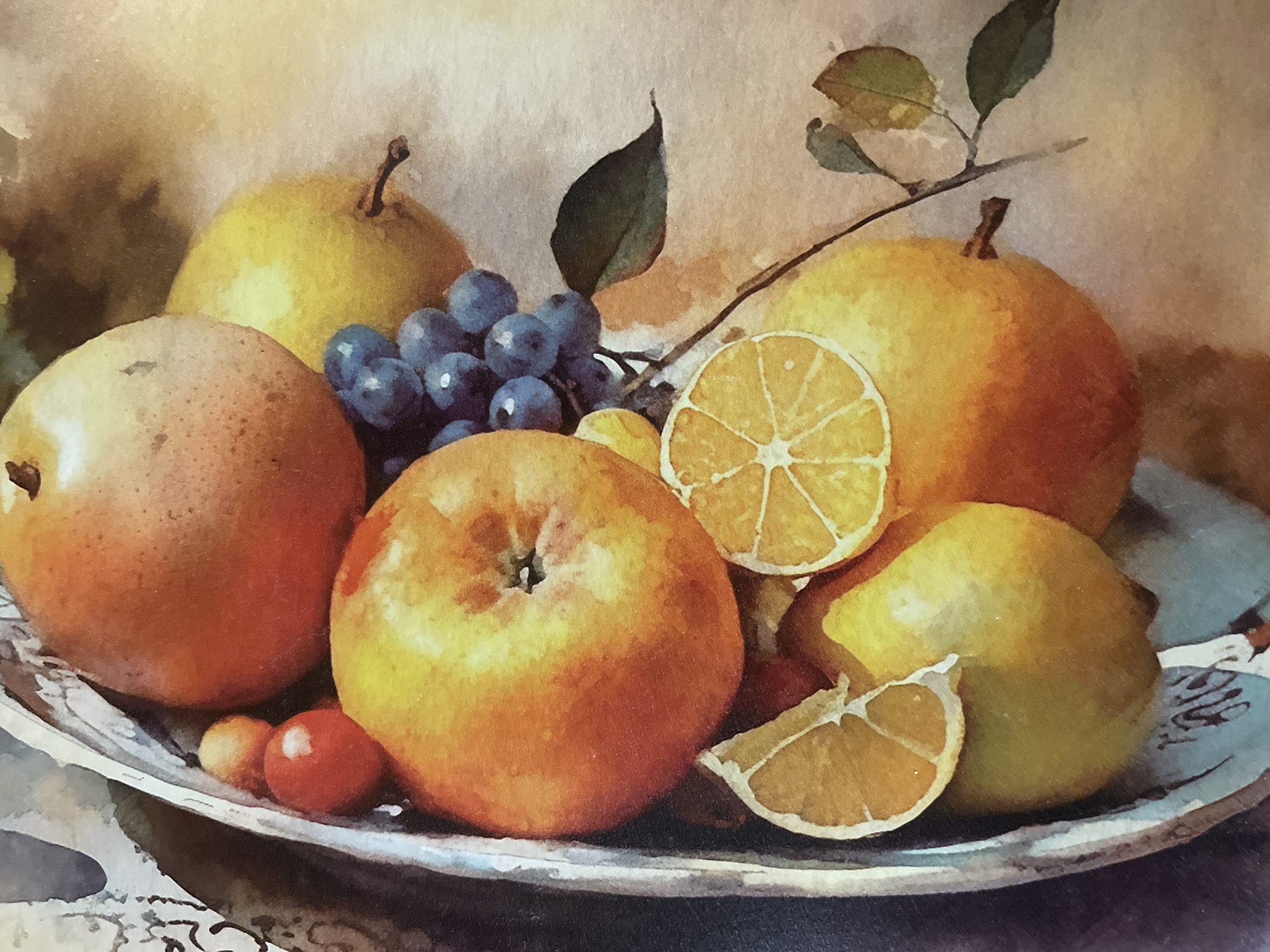 This is a watercolor painting of a fruit still life. The arrangement includes a large, round, orange-red fruit, possibly an apple or peach, at the top. To its right is a yellowish pear. Below these are more oranges or tangerines, one of which has slices of lemon placed on it. There is a bunch of dark blue grapes with a thin branch and green leaves extending from them. The fruits are in a bowl or platter that appears to be made of metal, with a decorative edge. The background is a soft, muted color, suggesting a studio setting. There are no people or any indication of a location in Minsk, Belarus.