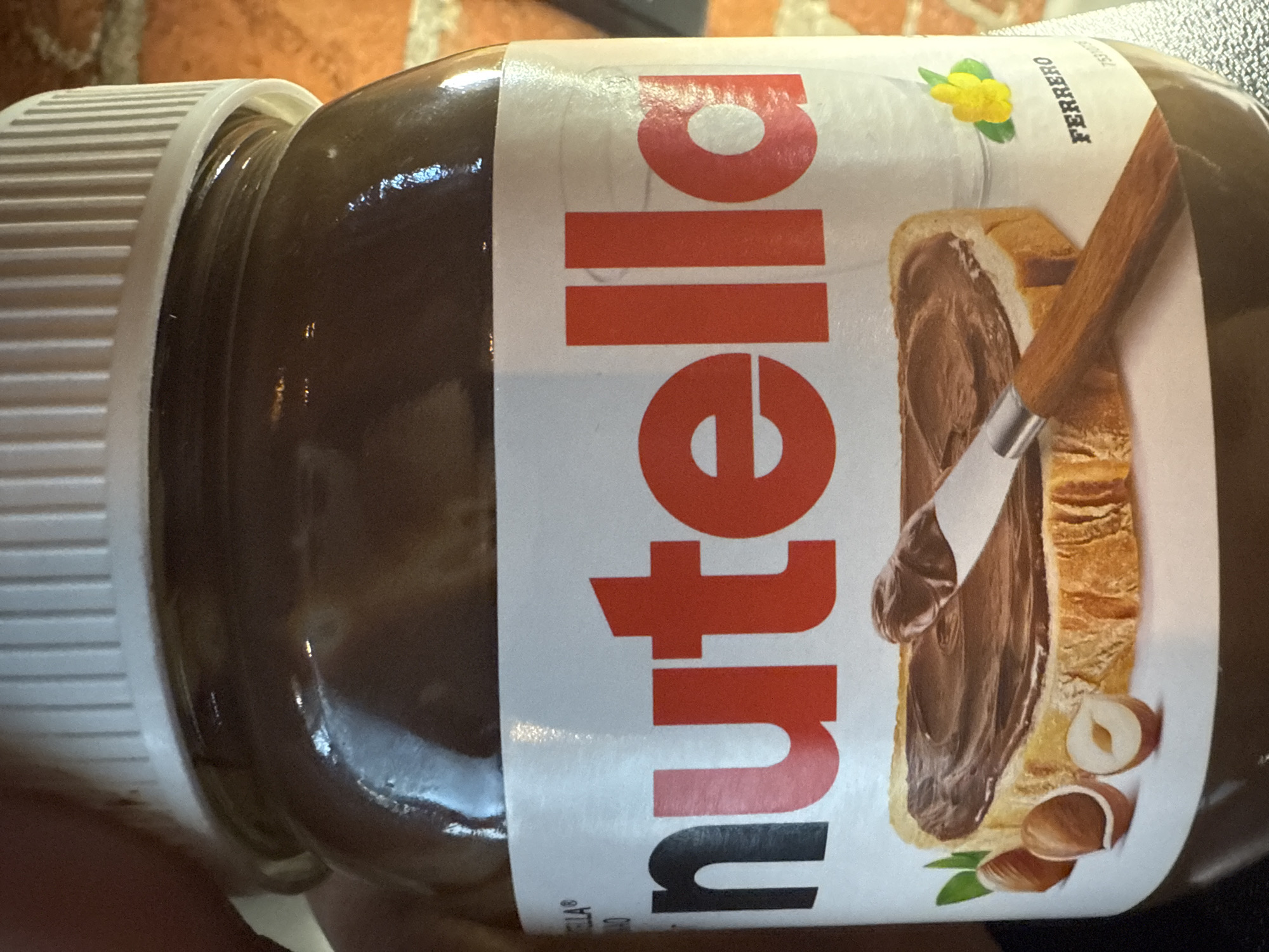 A jar of Nutella is prominently displayed. The label features the word "Nutella" in bold, red lettering, alongside an image of a slice of bread covered in the hazelnut spread with a knife applying more of it, with whole hazelnuts next to the bread. There is no evidence of a location in Moscow, Russia.