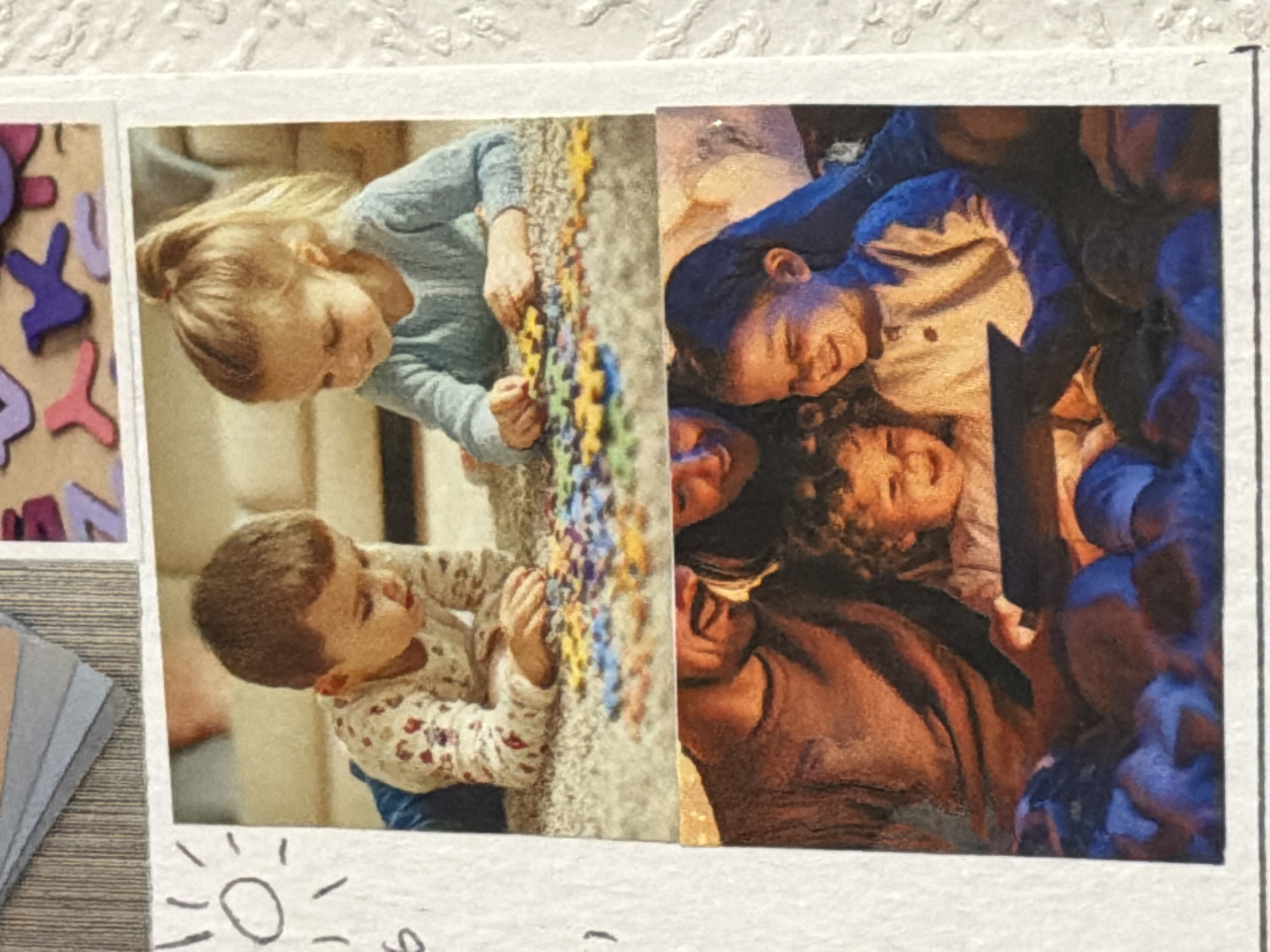 The image shows two adjacent snapshots affixed to a textured white surface. On the left, a fair-haired girl in a blue sweater and a boy in a patterned shirt are seen working on a colorful puzzle. On the right, a group of people, including a woman with dark hair and a curly-haired child, appear to be reading a book with a bright light source, perhaps a flashlight, illuminating their faces. The setting or the location in Moscow, Russia, is not discernible from the image.