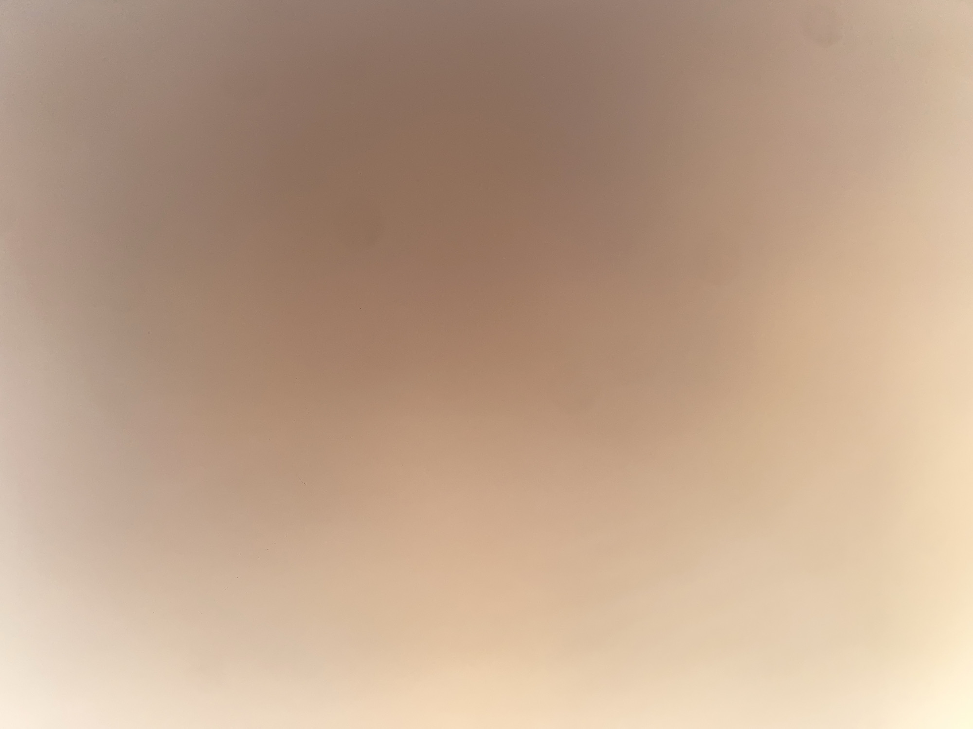 The image is a blurry, abstract photograph with a smooth gradient of light beige and peach tones. The lighting appears to be soft and diffused, casting a warm glow across the surface. There are no discernible objects, people, or actions within the frame. The image is a representation of a texture or a background rather than a specific scene or location. Therefore, it is impossible to determine its location in the city of Ablanitsa, Bulgaria, or any other geographical context.