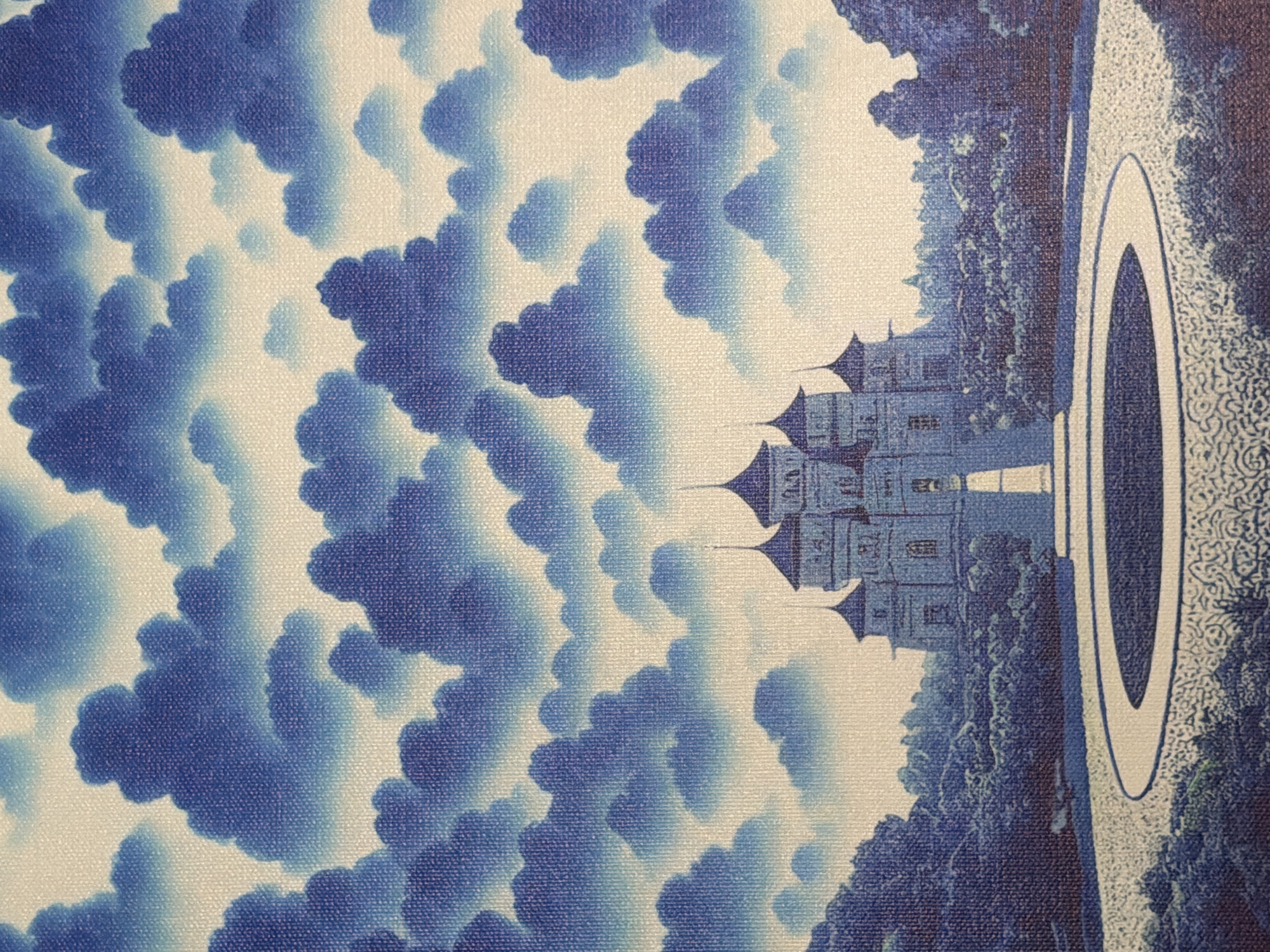 The image depicts a fantasy-style castle surrounded by lush greenery and a circular pathway leading to a central well or fountain. The sky above is filled with dramatic, swirling blue clouds. The architecture of the castle suggests a whimsical, almost fairytale-like aesthetic with its numerous towers and spires. The foreground features a patterned walkway and decorative landscaping. The overall impression is one of an idyllic and fantastical setting. There are no people or animals visible in the image. This image does not depict any location in the city of Naberezhnye Chelny, Russia.