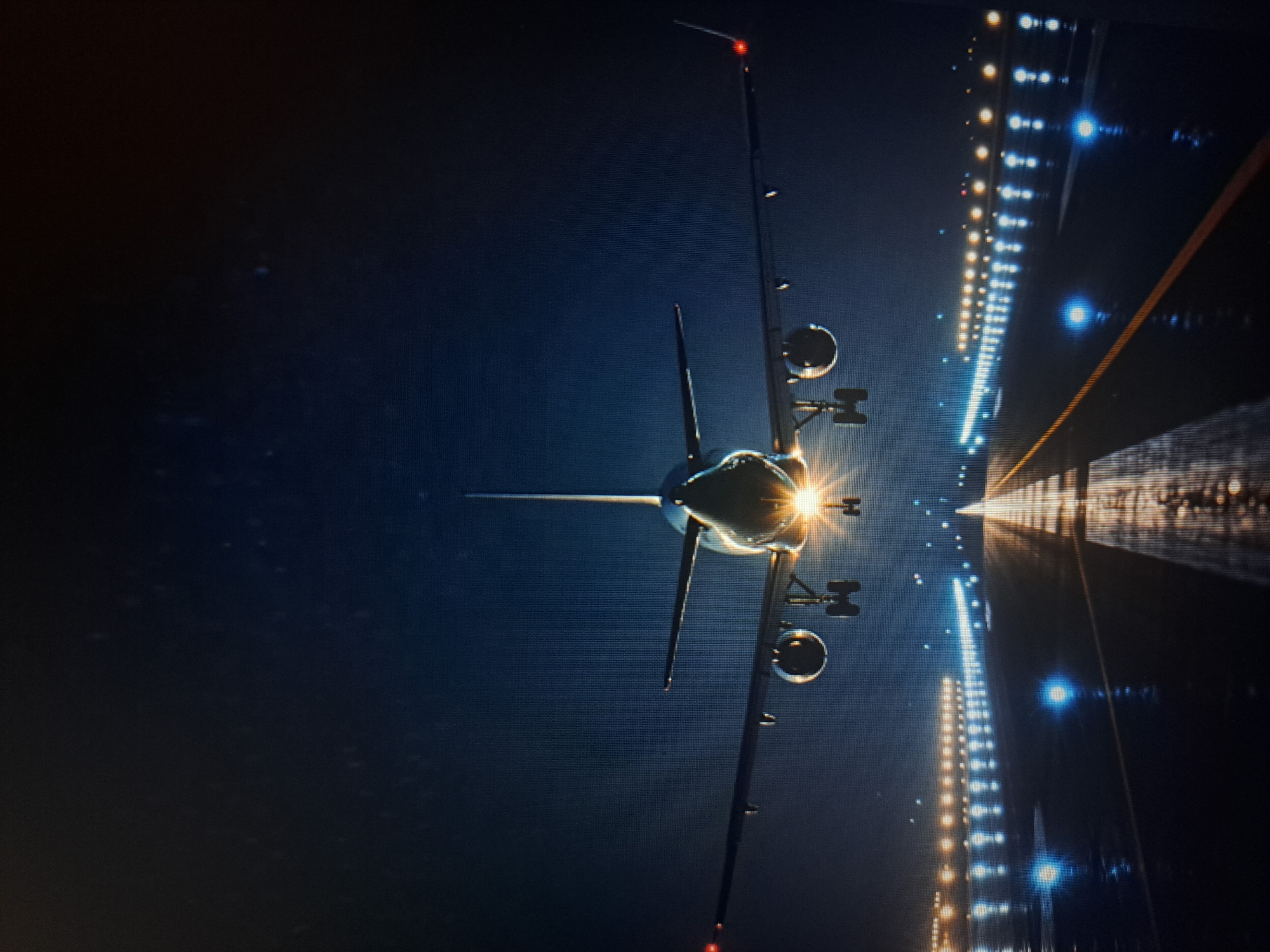 An airplane is aligned on a runway at night, with rows of lights guiding the way. The city of Yerevan, Armenia, is not apparent in the image.