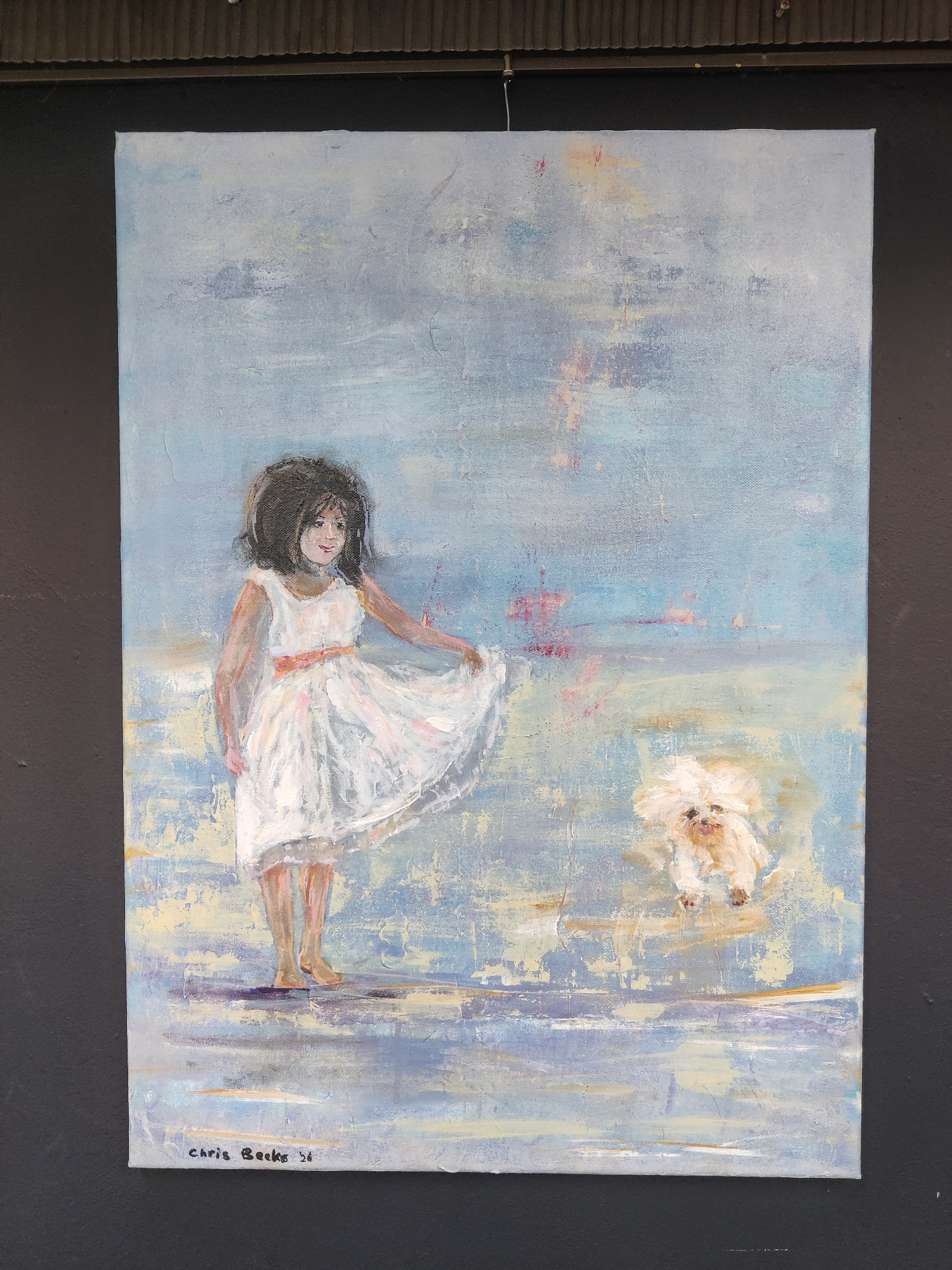 This is an acrylic painting on canvas depicting a young girl in a white dress with an orange sash, playing with a small, fluffy white dog. The girl is holding up the hem of her dress with her right hand, and her left arm is extended outward. She has dark, curly hair and a smiling expression. The dog appears to be in mid-air, possibly jumping or running, with its tongue sticking out. The background is abstract, with washes of light blue, grey, and hints of pink and yellow, suggesting a soft, ethereal atmosphere. The ground beneath them is rendered with horizontal strokes of various blues and yellows, possibly representing water or a sandy surface reflecting light. The overall impression is one of playful innocence and a carefree moment.
The signature "Chris Becker '21" is visible in the bottom left corner of the painting. The context of Winterswijk, Netherlands, does not provide specific clues within the artwork itself, but suggests a European setting. The lighting and soft colors might indicate a bright, perhaps slightly overcast day, or an impressionistic representation rather than a literal depiction of time of day or weather. The emotions conveyed are primarily joy and lightheartedness.