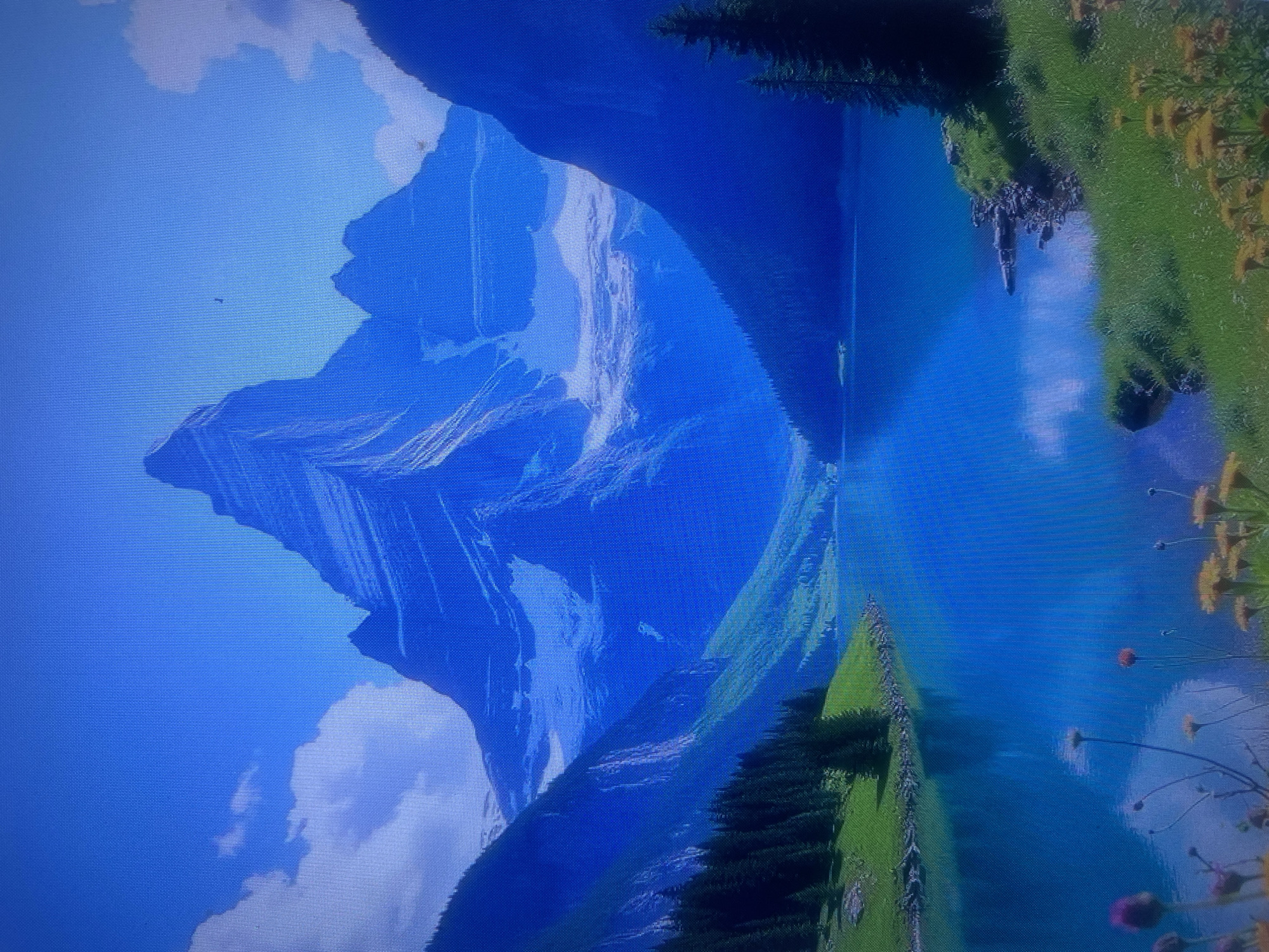 The media file depicts a serene mountain landscape with a vivid blue lake. The dominant subjects are the majestic, snow-capped mountains that rise dramatically in the background, their rugged peaks etched against a clear blue sky dotted with fluffy white clouds. To the right, a lush green slope covered in grass and scattered yellow wildflowers cascades down towards the water's edge. Dense green pine trees are visible on the slopes and a lone evergreen tree stands tall on a rocky outcrop. The lake itself is a striking azure, reflecting the sky and mountains, creating a sense of depth and tranquility.
There is no discernible activity or event taking place, suggesting a peaceful, static scene. Notable details include the time of day, which appears to be daytime with bright sunlight, and the weather, which is clear and fair. The location cues are limited to the natural elements of mountains, lake, and flora, but the provided location context is Samara, Russia. The overall emotion conveyed is one of peace, beauty, and awe. There is no visible text in the image.