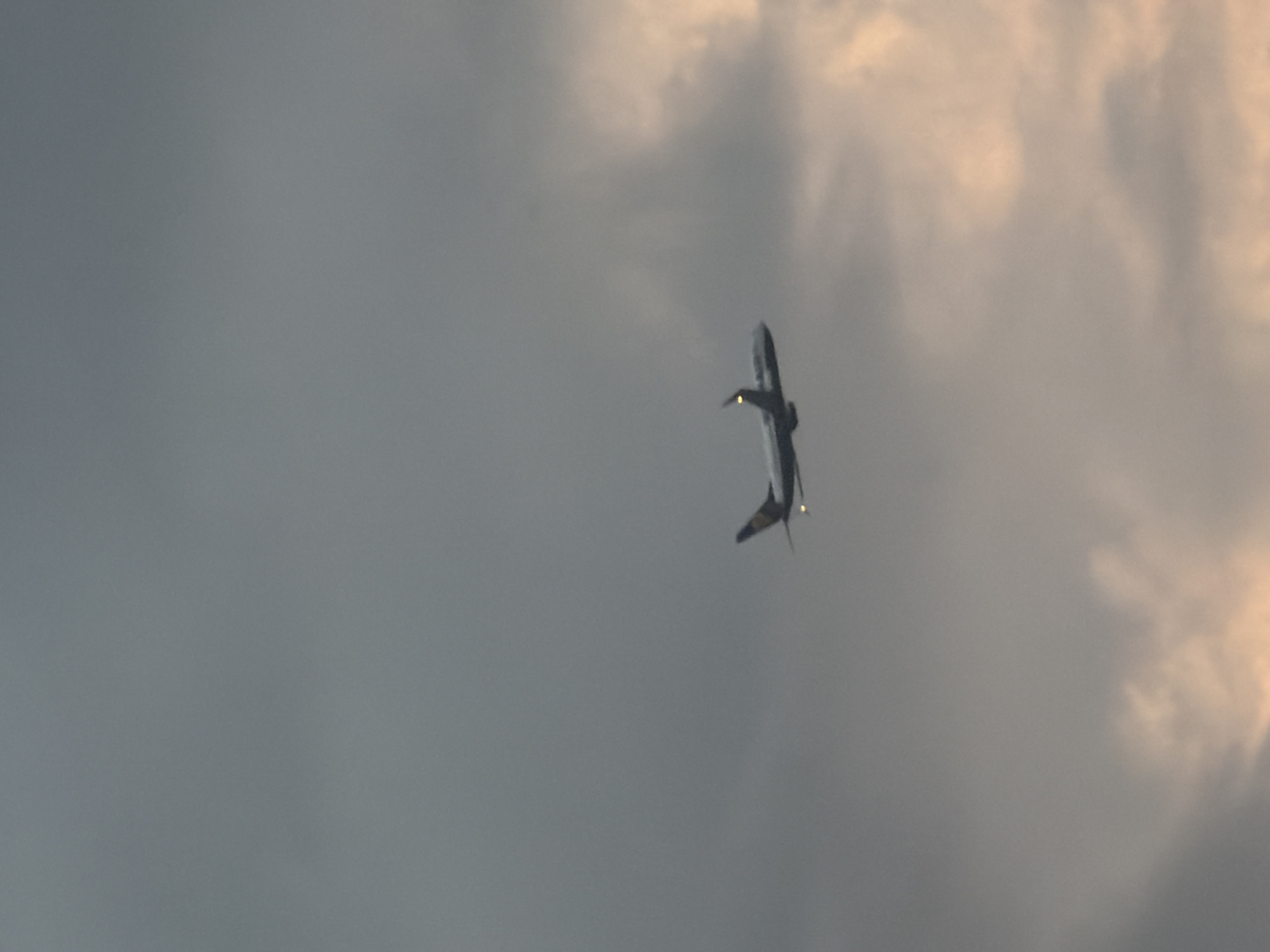 The image shows an airplane in flight against a cloudy sky. The location cannot be determined solely from the image.